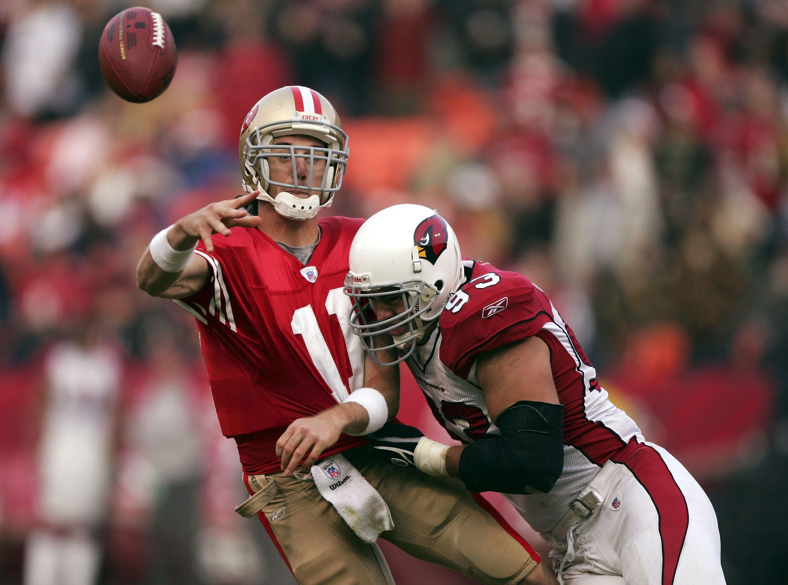 SAN FRANCISCO - DECEMBER 24:  Alex Smith #11 of the San Francisco 49ers is hit by Chris Cooper #93 of the Arizona Cardinals during an NFL game at Monster Park on December 24, 2006 in San Francisco, California.  (Photo by Jed Jacobsohn/Getty Images)