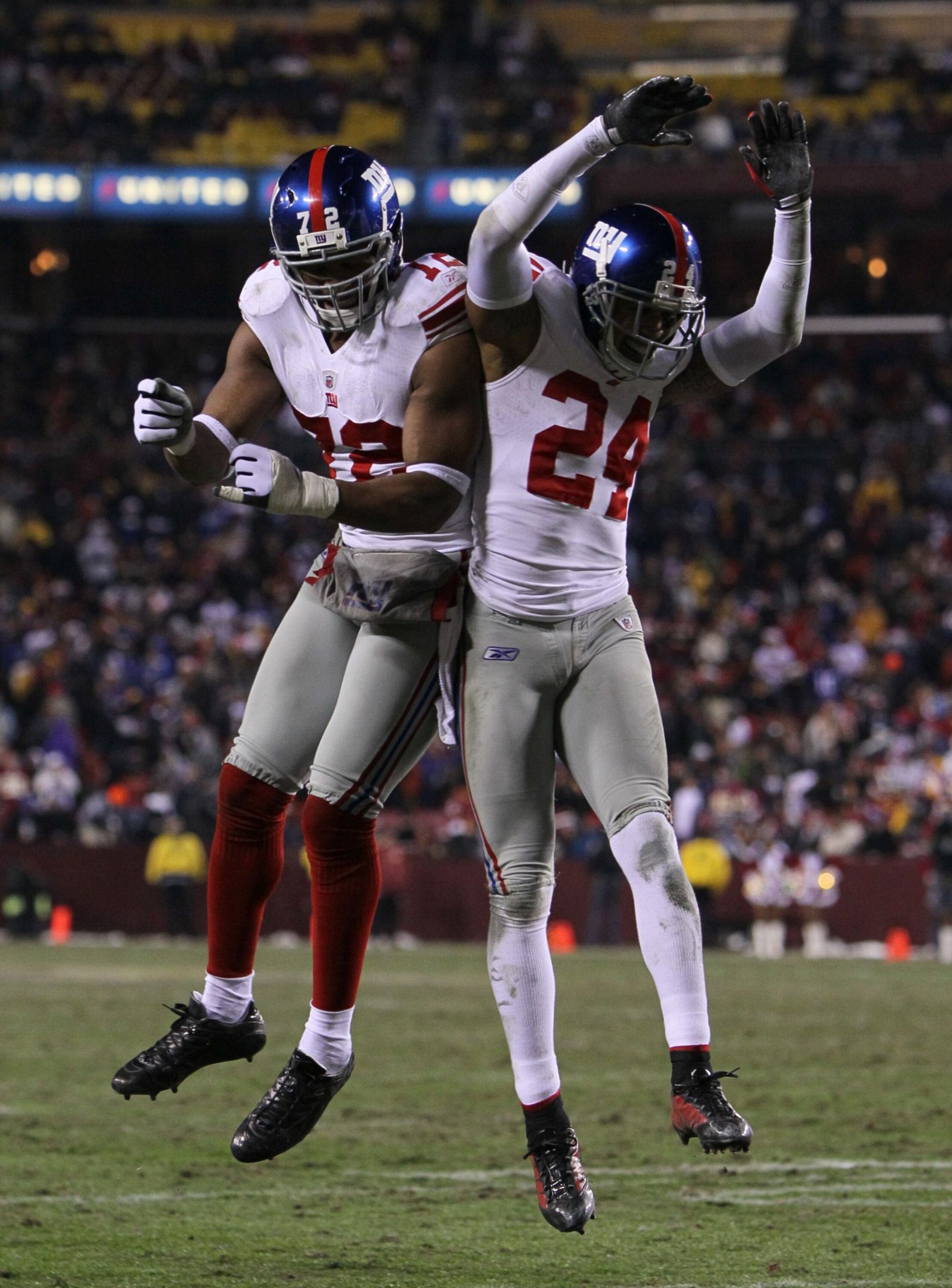 LANDOVER, MD - DECEMBER 21:  (R-L) Terrell Thomas #24 of the New York Giants and Osi Umenyiora #72 celebrate after Thomas scored on an interception return for a touchdown in the third quarter against  the Washington Redskins at FedEx Field on December 21,