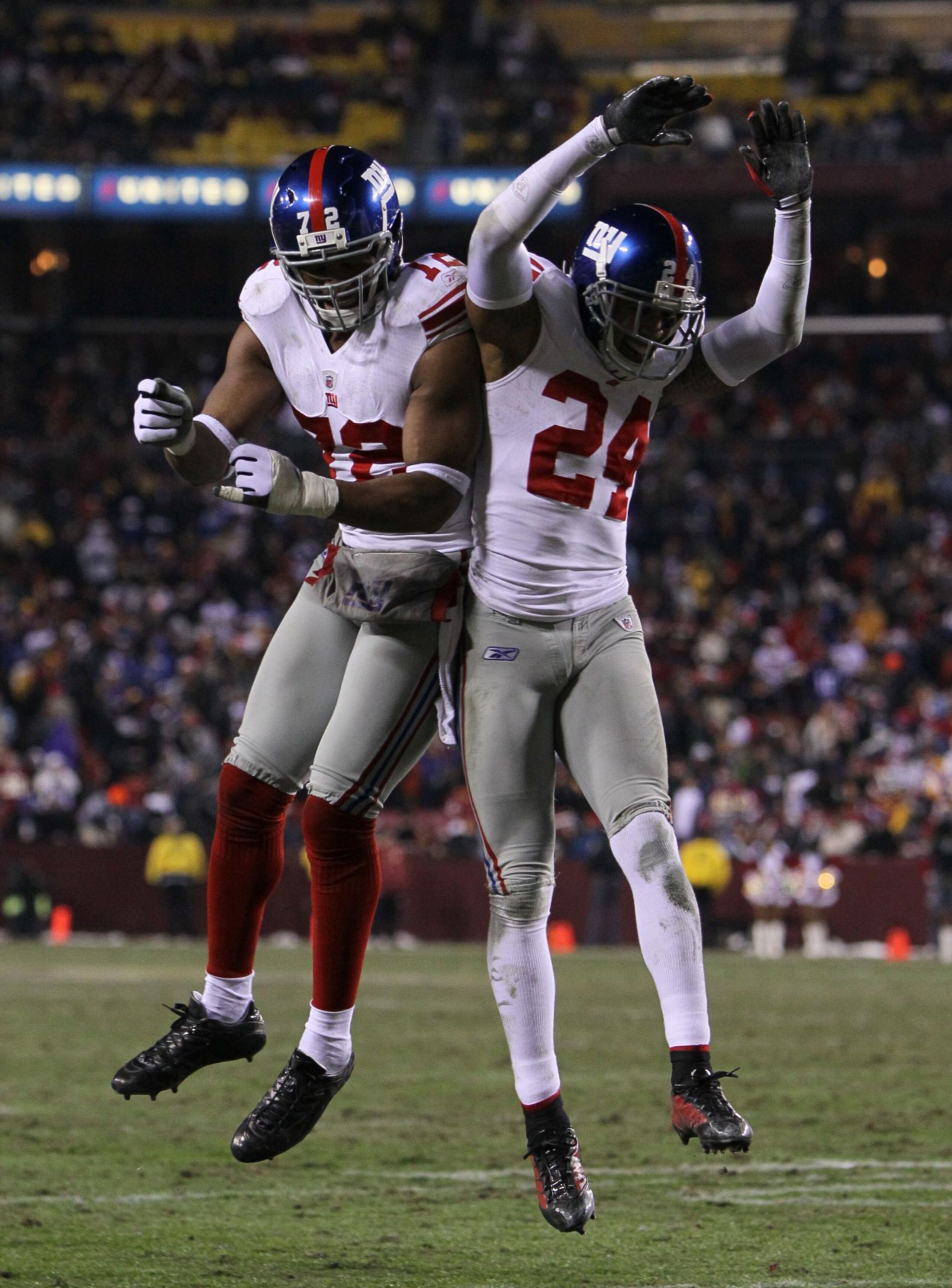 LANDOVER, MD - DECEMBER 21:  (R-L) Terrell Thomas #24 of the New York Giants and Osi Umenyiora #72 celebrate after Thomas scored on an interception return for a touchdown in the third quarter against  the Washington Redskins at FedEx Field on December 21,