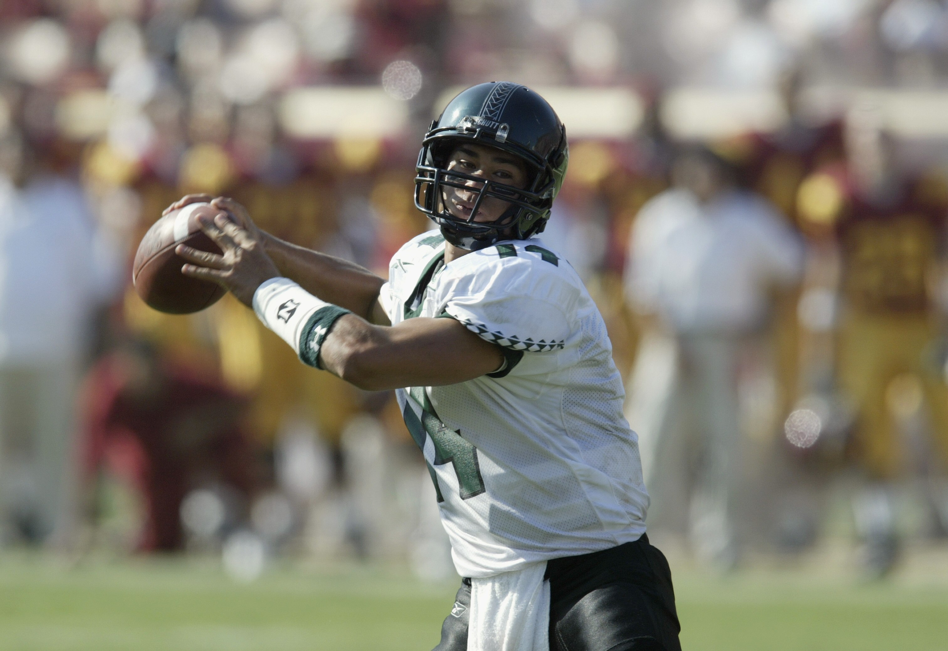 LOS ANGELES - SEPTEMBER 13:  Timmy Chang #14 of the University of Hawaii Warriors throws a touchdown pass against the University of Southern California Trojans at the Los Angeles Coliseum on September 13, 2003 in Los Angeles, California.  USC defeated Haw
