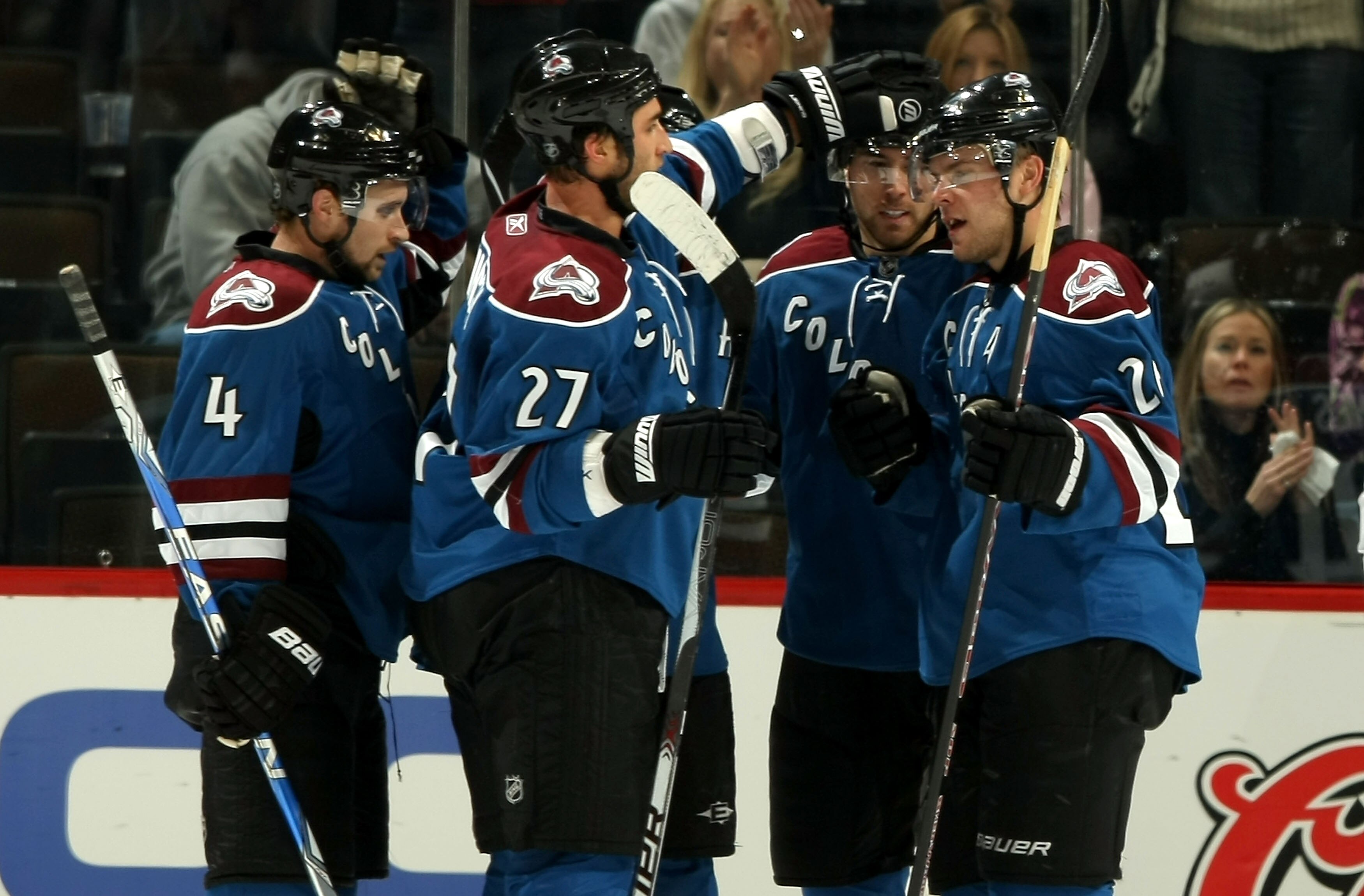 DENVER - NOVEMBER 25:  John-Michael Liles #4, Kyle Quincey #27, David Jones #54 and Paul Stastny #26 of the Colorado Avalanche celebrate a second period goal by Milan Hejduk (hidden) against the Nashville Predators during NHL action at the Pepsi Center on