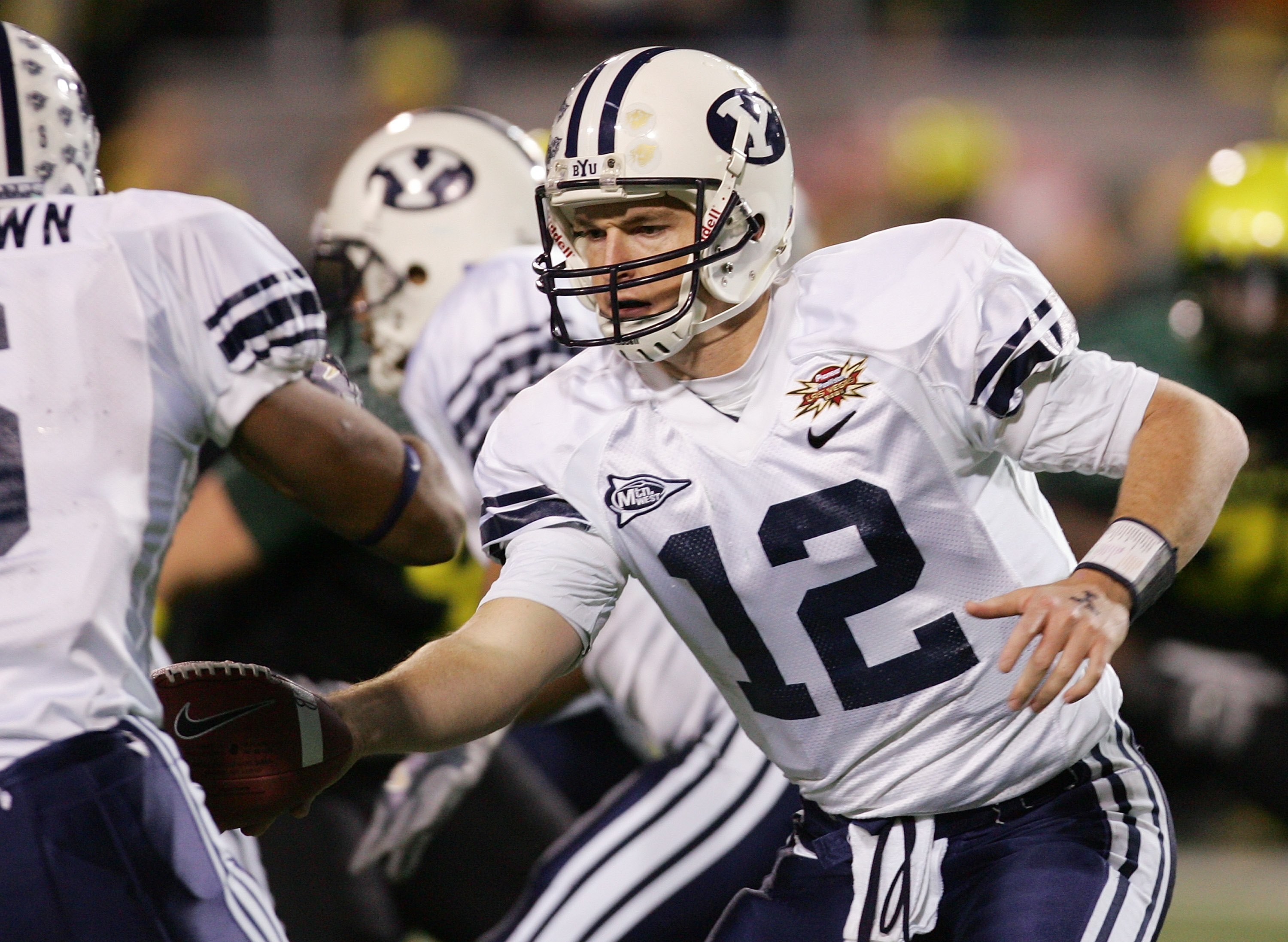 LAS VEGAS - DECEMBER 21:  Brigham Young University quarterback John Beck #12 hands the ball off as the Cougars take on the Oregon Ducks during the second quarter of the Pioneer PureVision Las Vegas Bowl at Sam Boyd Stadium December 21, 2006 in Las Vegas,