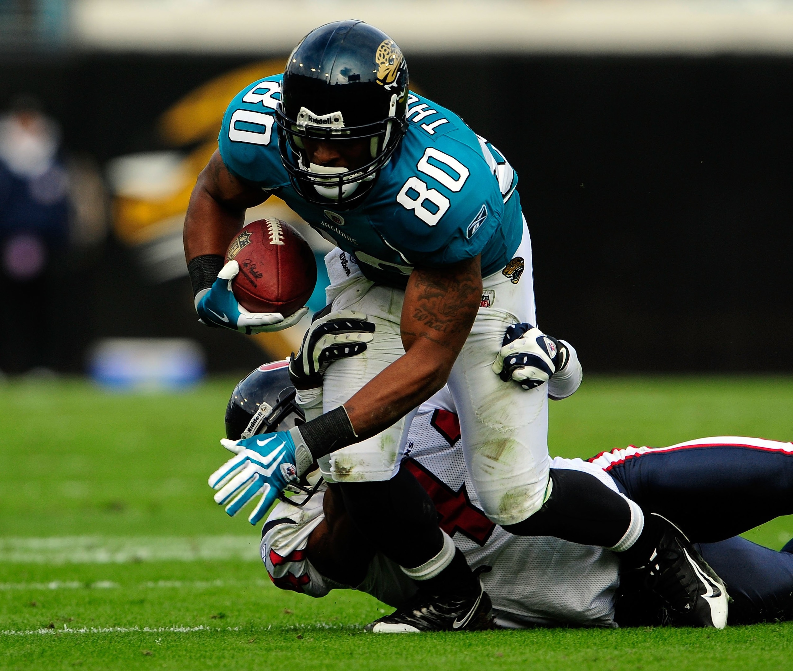 JACKSONVILLE, FL - DECEMBER 06:  Mike Thomas #80 of the Jacksonville Jaguars is tackled by Brice McCain #41 of the Houston Texans during the game at Jacksonville Municipal Stadium on December 6, 2009 in Jacksonville, Florida.  (Photo by Sam Greenwood/Gett
