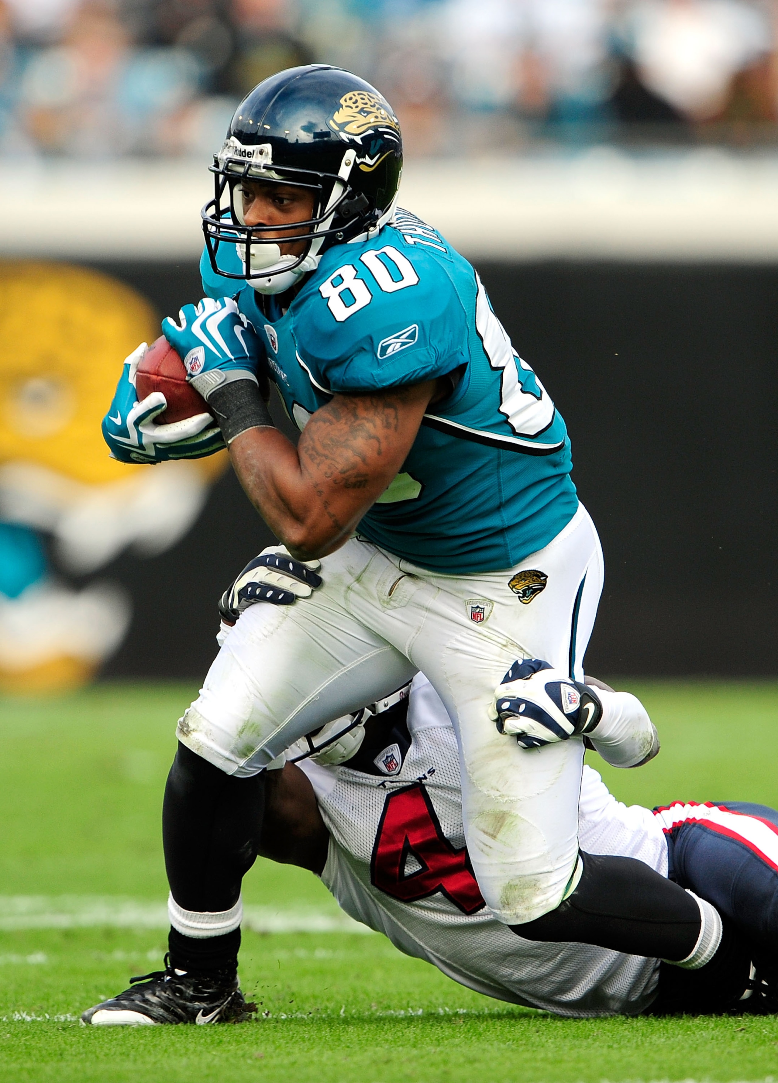 JACKSONVILLE, FL - DECEMBER 06:  Mike Thomas #80 of the Jacksonville Jaguars is tackled by Brice McCain #41 of the Houston Texans during the game at Jacksonville Municipal Stadium on December 6, 2009 in Jacksonville, Florida.  (Photo by Sam Greenwood/Gett