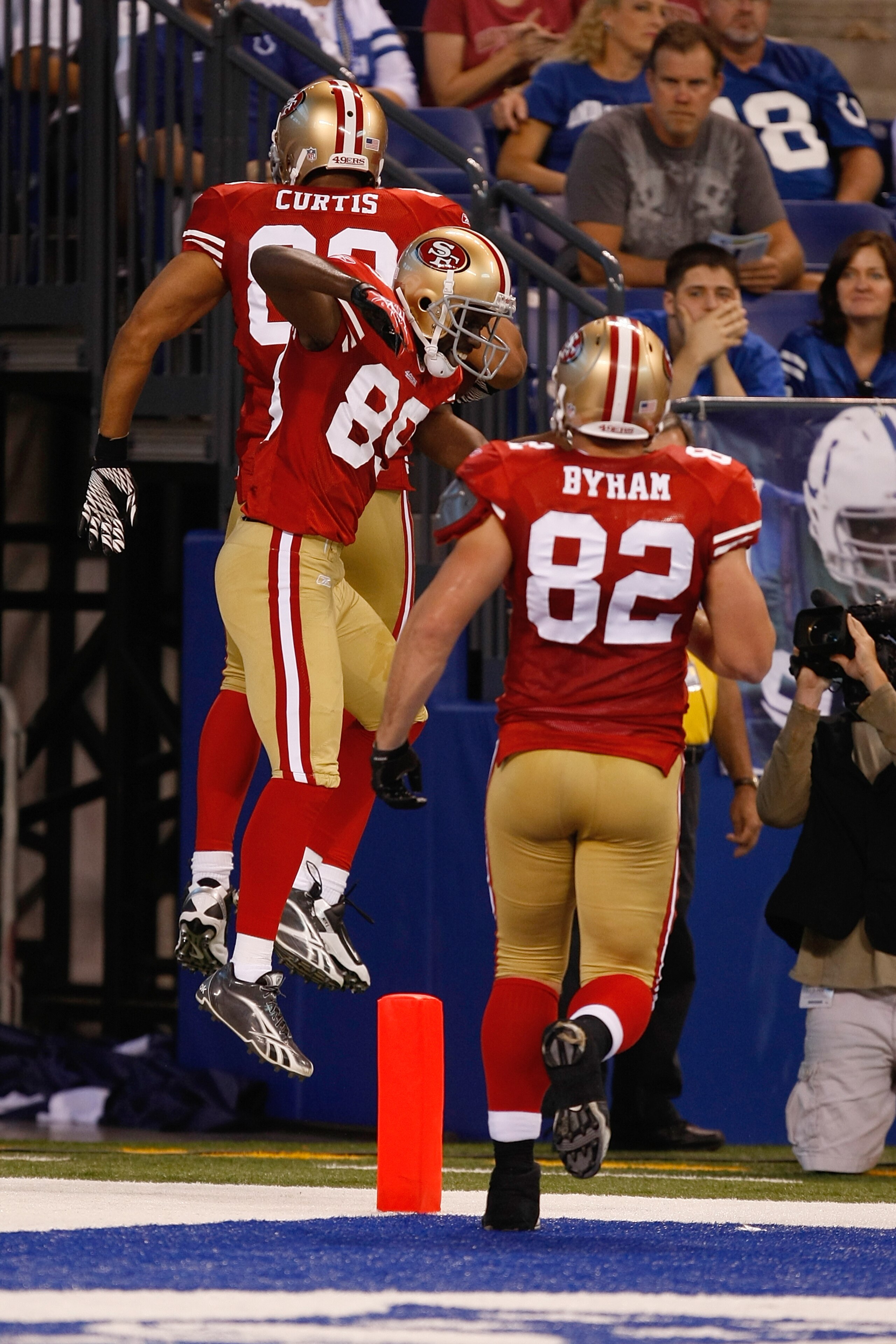 INDIANAPOLIS, IN - AUGUST 15: Tony Curtis #89, Nate Byham #82 and Jason Hill #89 of the San Francisco 49ers jump in the air to celebrate a touchdown during the preseason game against the Indianapolis Colts at Lucas Oil Stadium on August 15, 2010 in Indian
