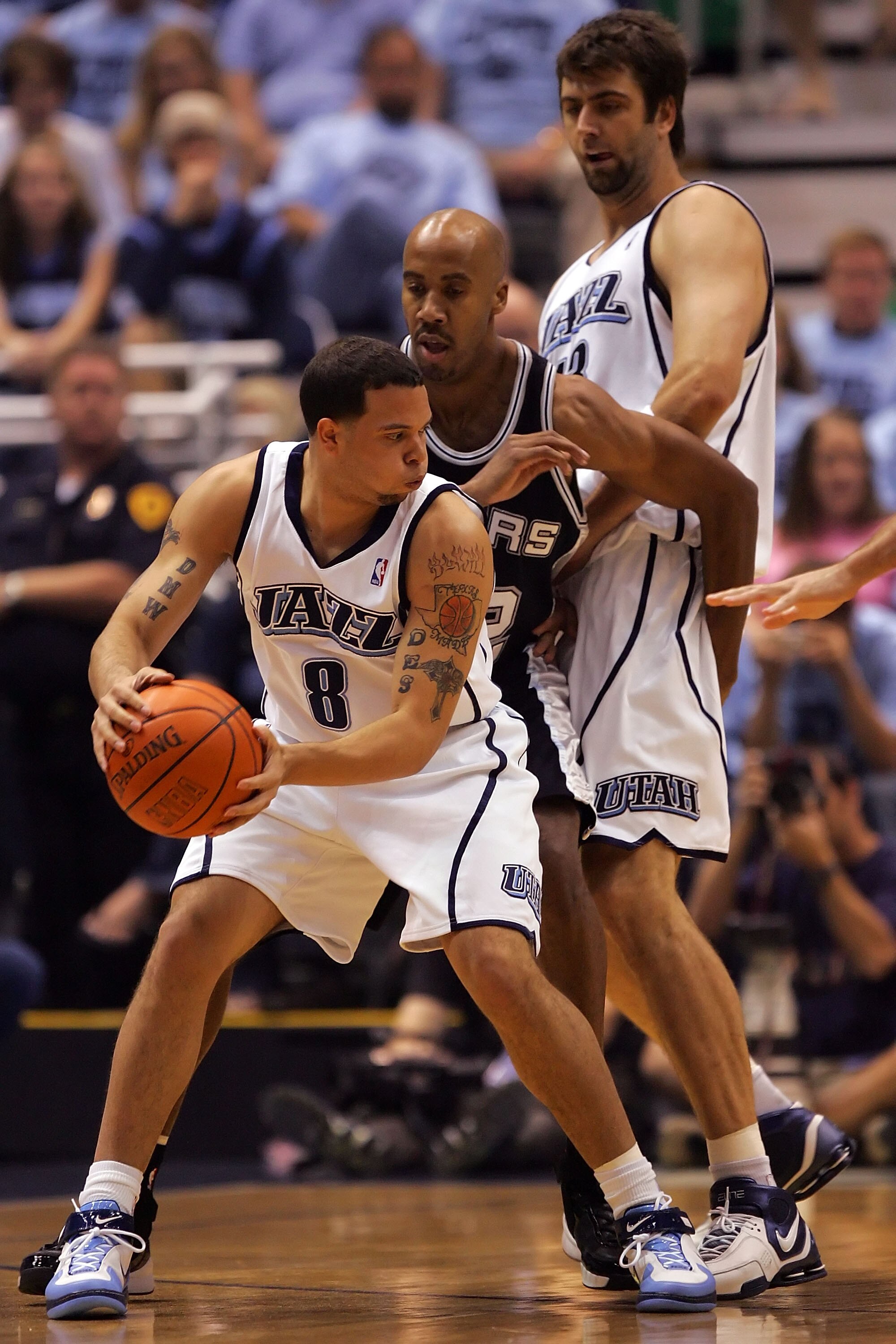 SALT LAKE CITY - MAY 26:  Deron Williams #8 of the Utah Jazz looks to go around Bruce Bowen #12 of the San Antonio Spurs as teammate Mehmet Okur #13 sets a screen in the first quarter of Game Three of the Western Conference Finals during the 2007 NBA Play
