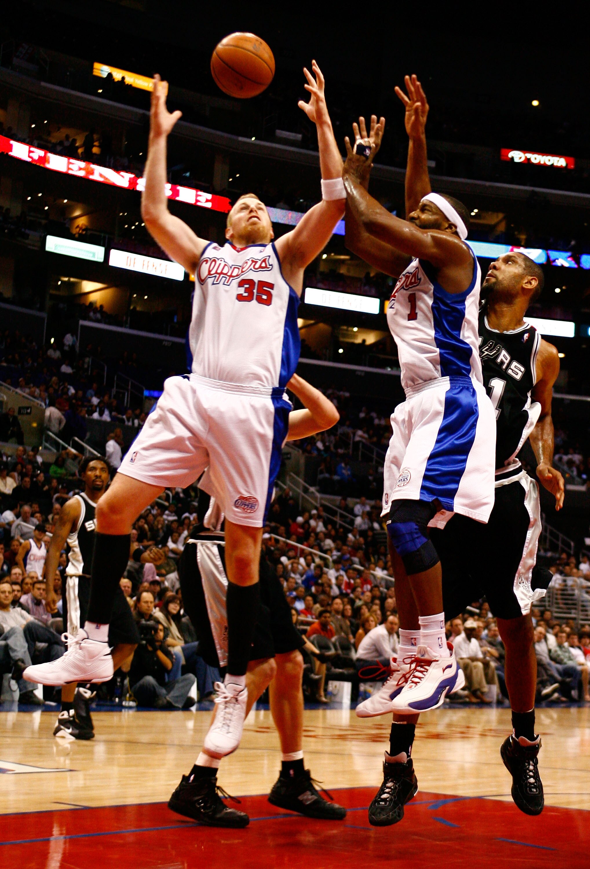 LOS ANGELES, CA - NOVEMBER 17:  Chris Kaman #35 and Baron Davis #1 of the Los Angeles Clippers reach for a rebound against Tim Duncan #21 of the San Antonio Spurs during the fourth quarter at Staples Center on November 17, 2008 in Los Angeles, California.