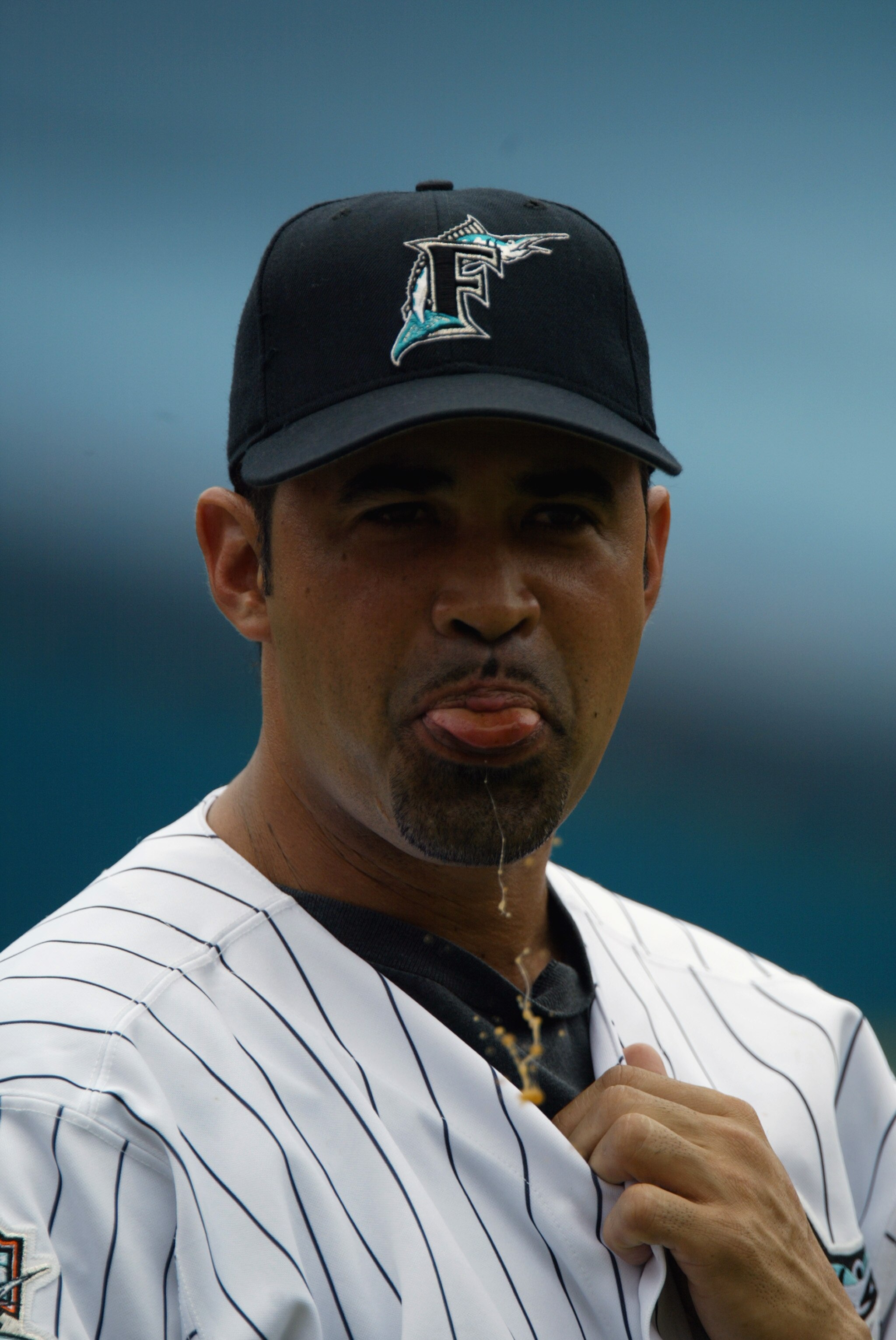 MIAMI - JUNE 22:  Third base coach Ozzie Guillen #13 of the Florida Marlins spits between signals during MLB Interleague play against the Tampa Bay Devil Rays at Pro Player Stadium on June 22, 2003 in Miami, Florida. The Marlins won 3-2. (Photo By Eliot J