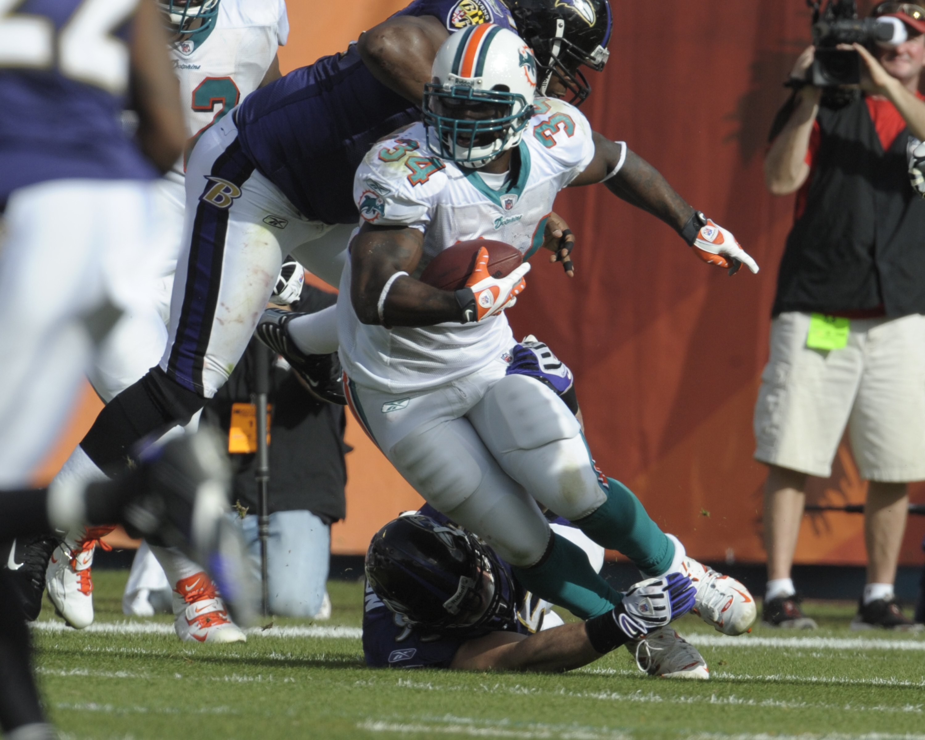 MIAMI, FL - JANUARY 4:  Running back Ricky Williams #34 of the Miami Dolphins rushes upfield against the Baltimore Ravens in an NFL Wildcard Playoff Game at Dolphins Stadium on January 4, 2009 in Miami, Florida.  (Photo by Al Messerschmidt/Getty Images)