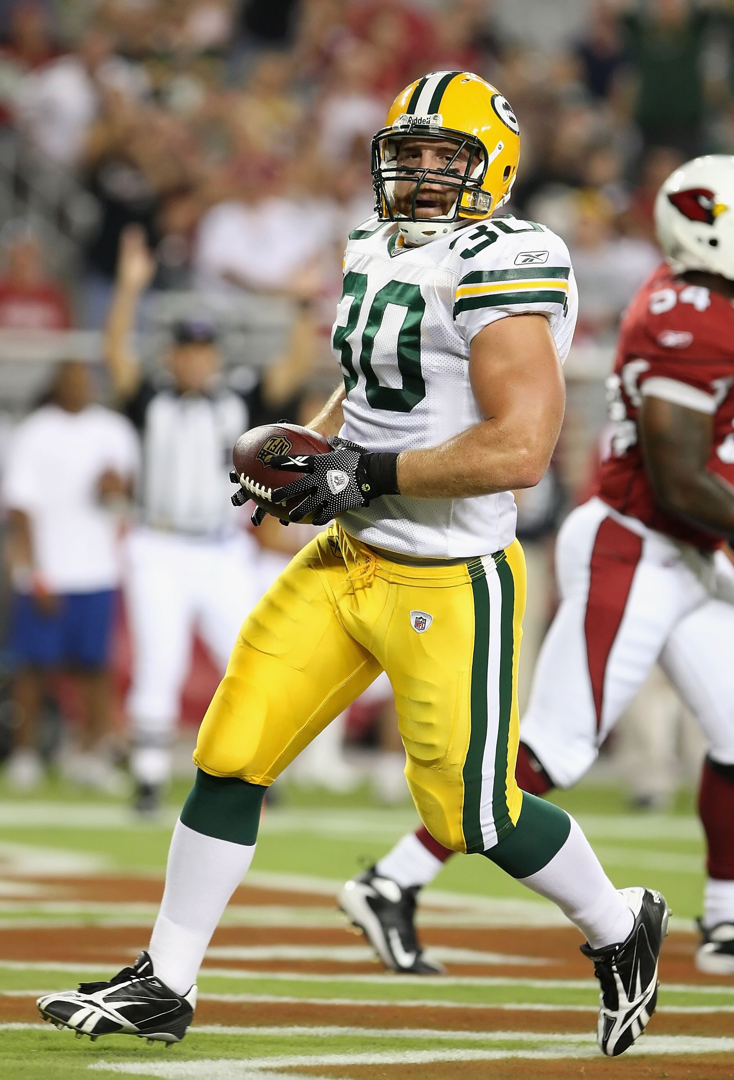 GLENDALE, AZ - AUGUST 28:  Fullback John Kuhn #30 of the Green Bay Packers rushes for a touchdown during the first quarter against the Arizona Cardinals at the University of Phoenix Stadium on August 28, 2009 in Glendale, Arizona. The Packers defeated the