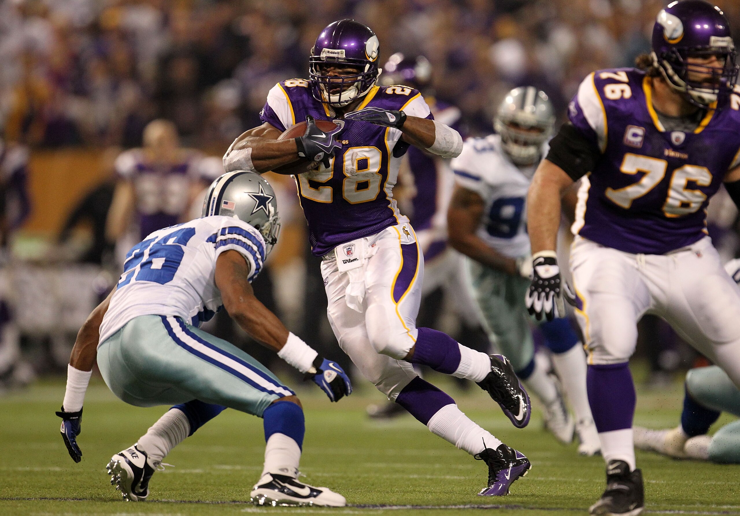 MINNEAPOLIS - JANUARY 17:  Running back Adrian Peterson #28 of the Minnesota Vikings runs the ball against Ken Hamlin #26 of the Dallas Cowboys during the second quarter of the NFC Divisional Playoff Game at Hubert H. Humphrey Metrodome on January 17, 201