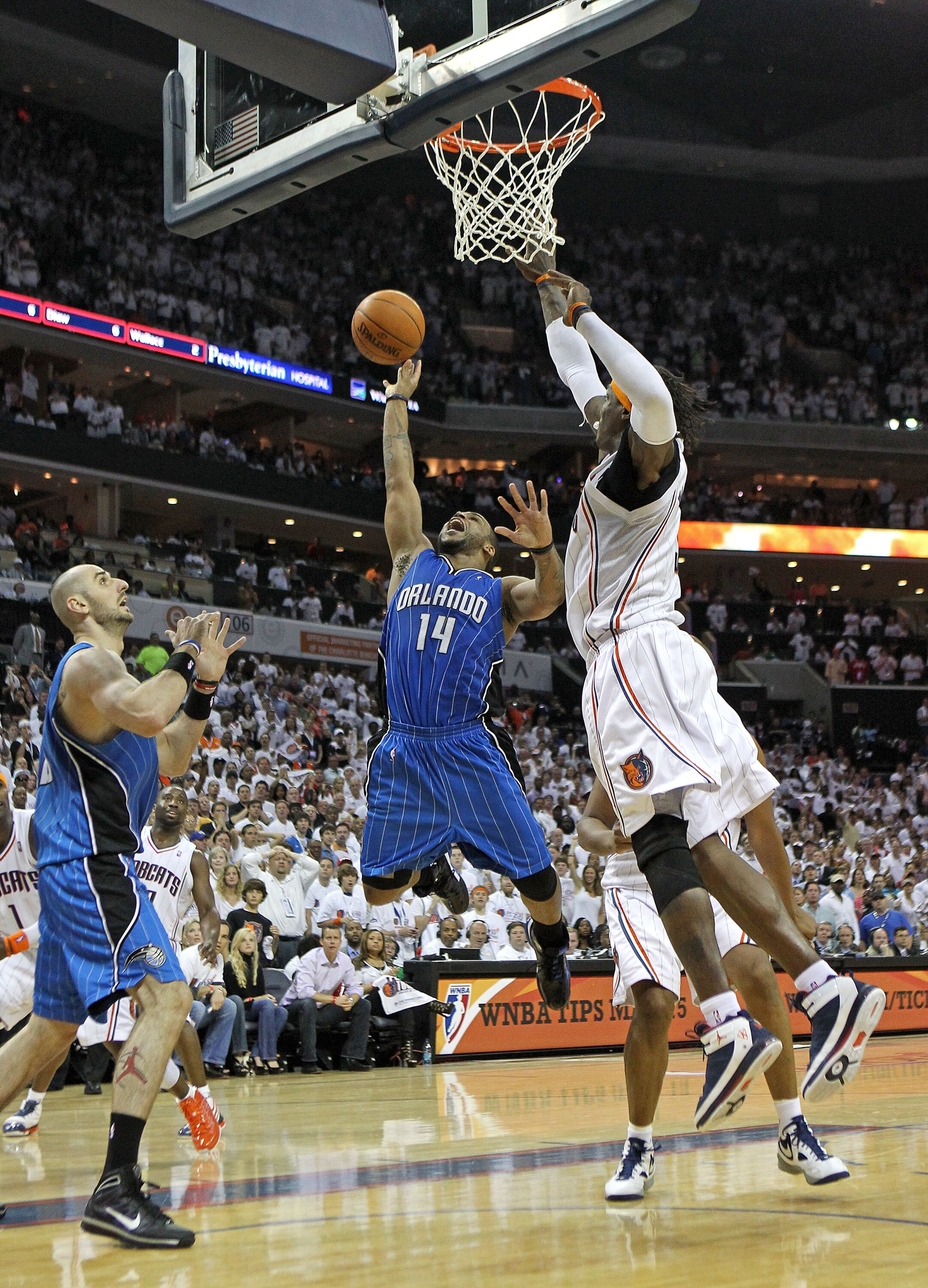 CHARLOTTE - APRIL 24:  Guard Jameer Nelson #14 of the Orlando Magic drives the lane while teammate Marcin Gortat #13 looks on (L) and Charlotte Bobcat forward Gerald Wallace #3 tries to block the shot during Game Three of the Eastern Conference Quarterfin
