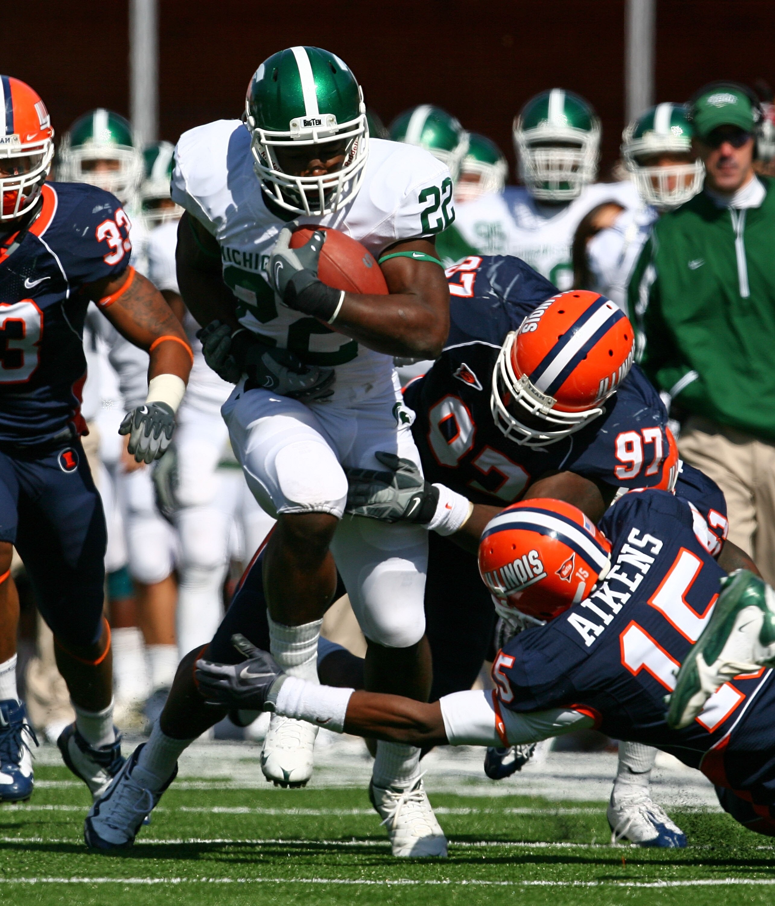 CHAMPAIGN, IL - OCTOBER 10: Larry Caper #22 of the Michigan State Spartans runs past Walter Aikens #15 and Clay Nurse #97 of the Illinois Fighting Illini on October 10, 2009 at Memorial Stadium at the University of Illinois in Champaign, Illinois. (Photo