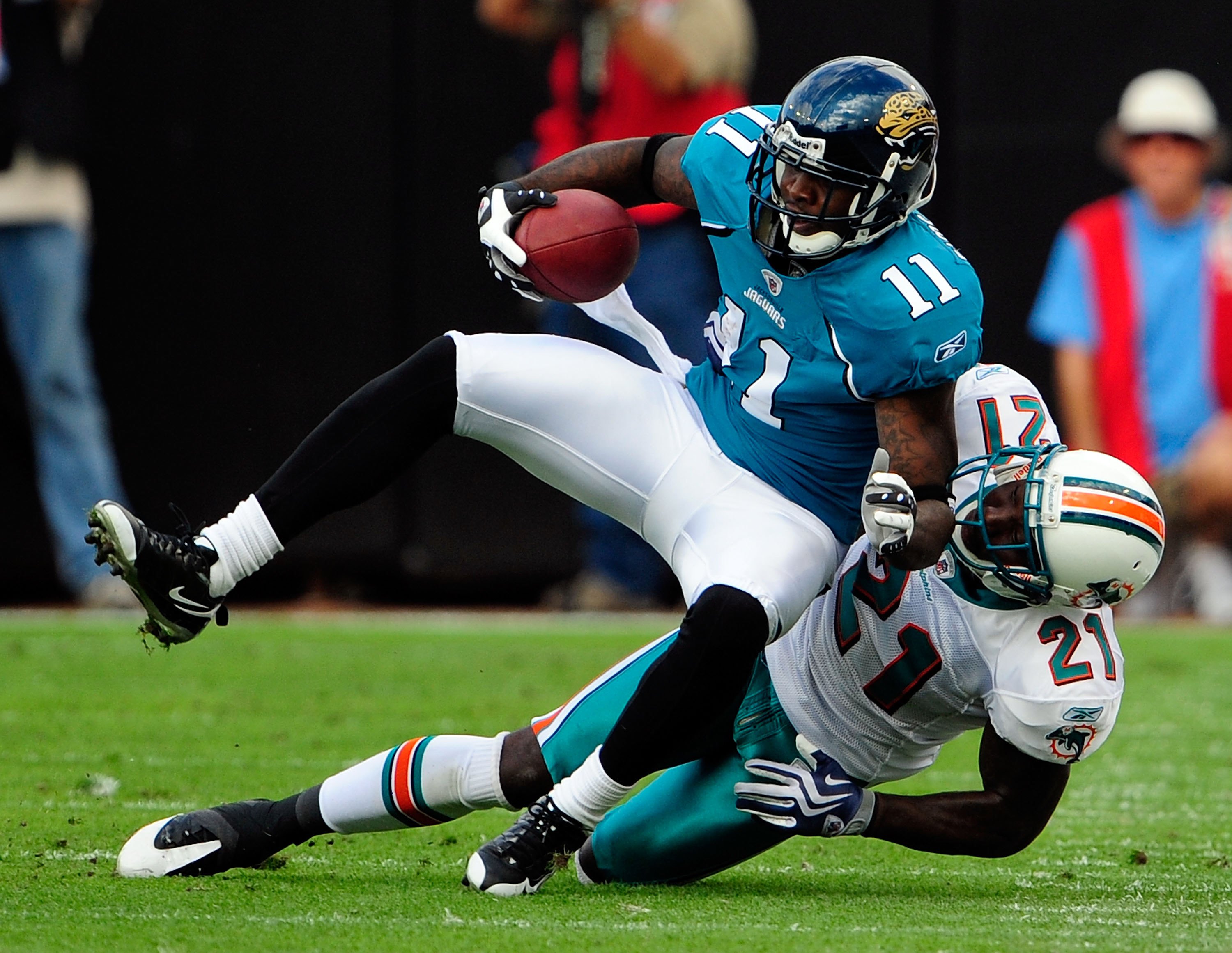 JACKSONVILLE, FL - DECEMBER 13:  Mike Sims-Walker #11 of the Jacksonville Jaguars is tackled by Vontae Davis #21 of the Miami Dolphins during the game at Jacksonville Municipal Stadium on December 13, 2009 in Jacksonville, Florida.  (Photo by Sam Greenwoo