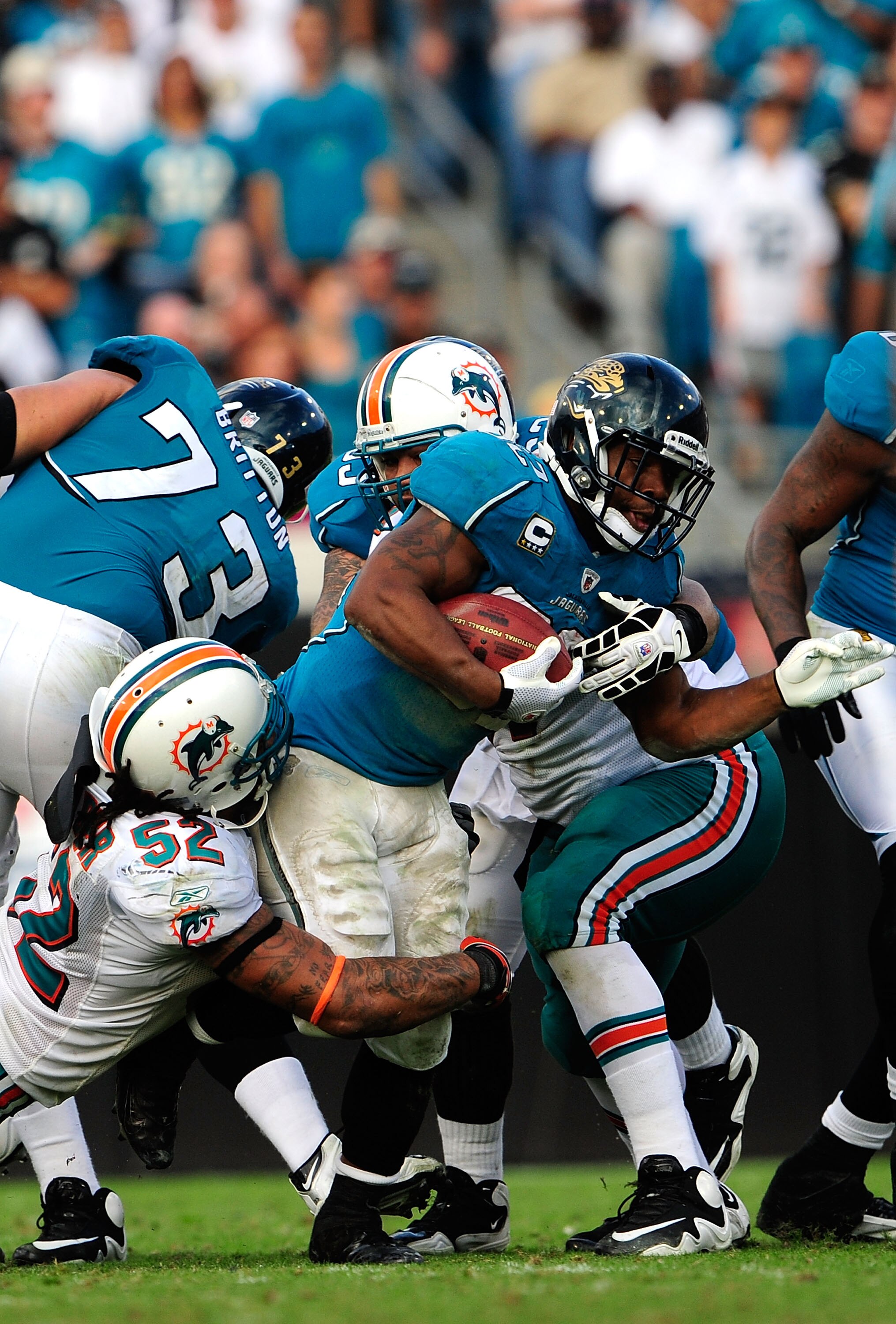 JACKSONVILLE, FL - DECEMBER 13:  Maurice Jones-Drew #32 of the Jacksonville Jaguars is tackled by Channing Crowder #52 of the Miami Dolphins during the game at Jacksonville Municipal Stadium on December 13, 2009 in Jacksonville, Florida.  The Dolphins won
