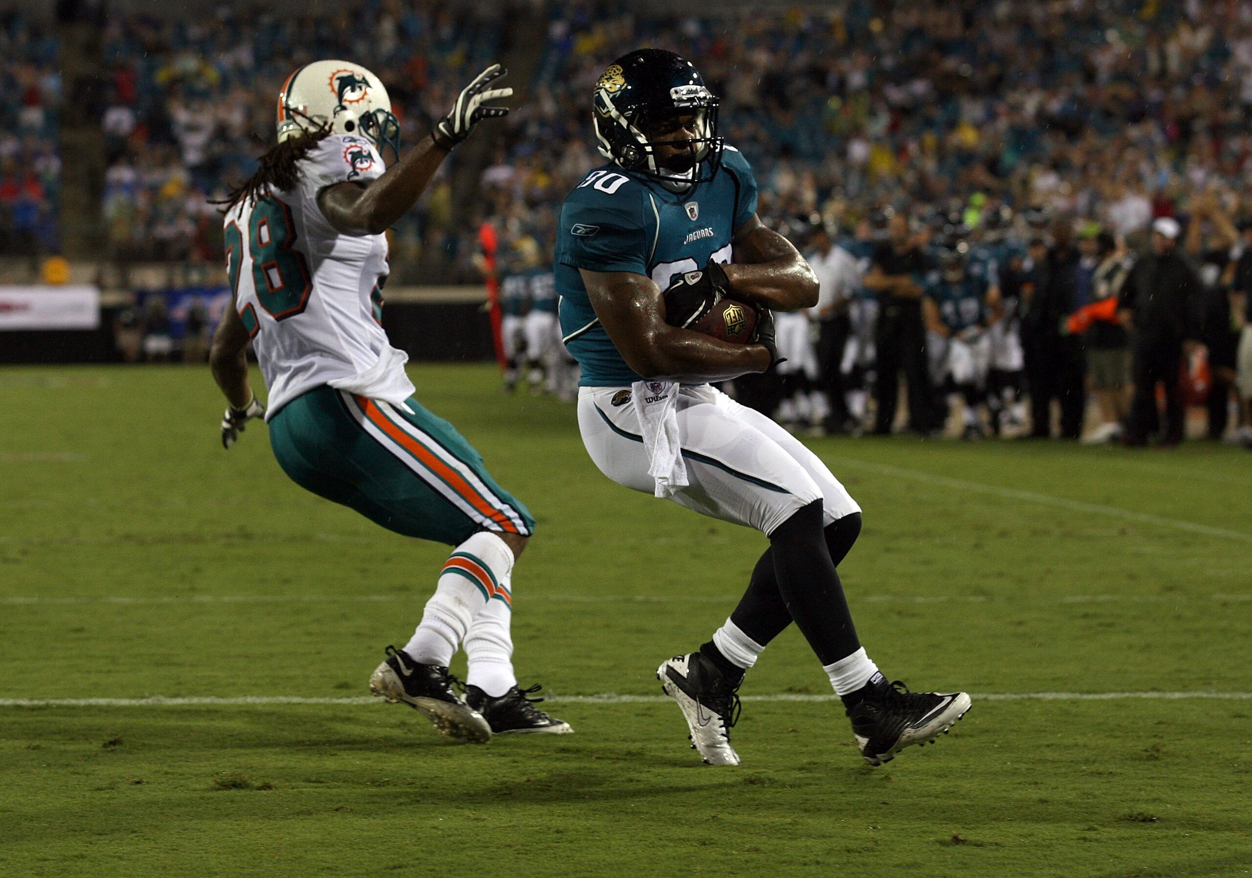 JACKSONVILLE, FL - AUGUST 21:  Mike Thomas #80 of the Jacksonville Jaguars scores a touchdown against Nolan Carroll #28 of the Miami Dolphinsduring the preseason game at EverBank Field on August 21, 2010 in Jacksonville, Florida.  (Photo by Sam Greenwood/
