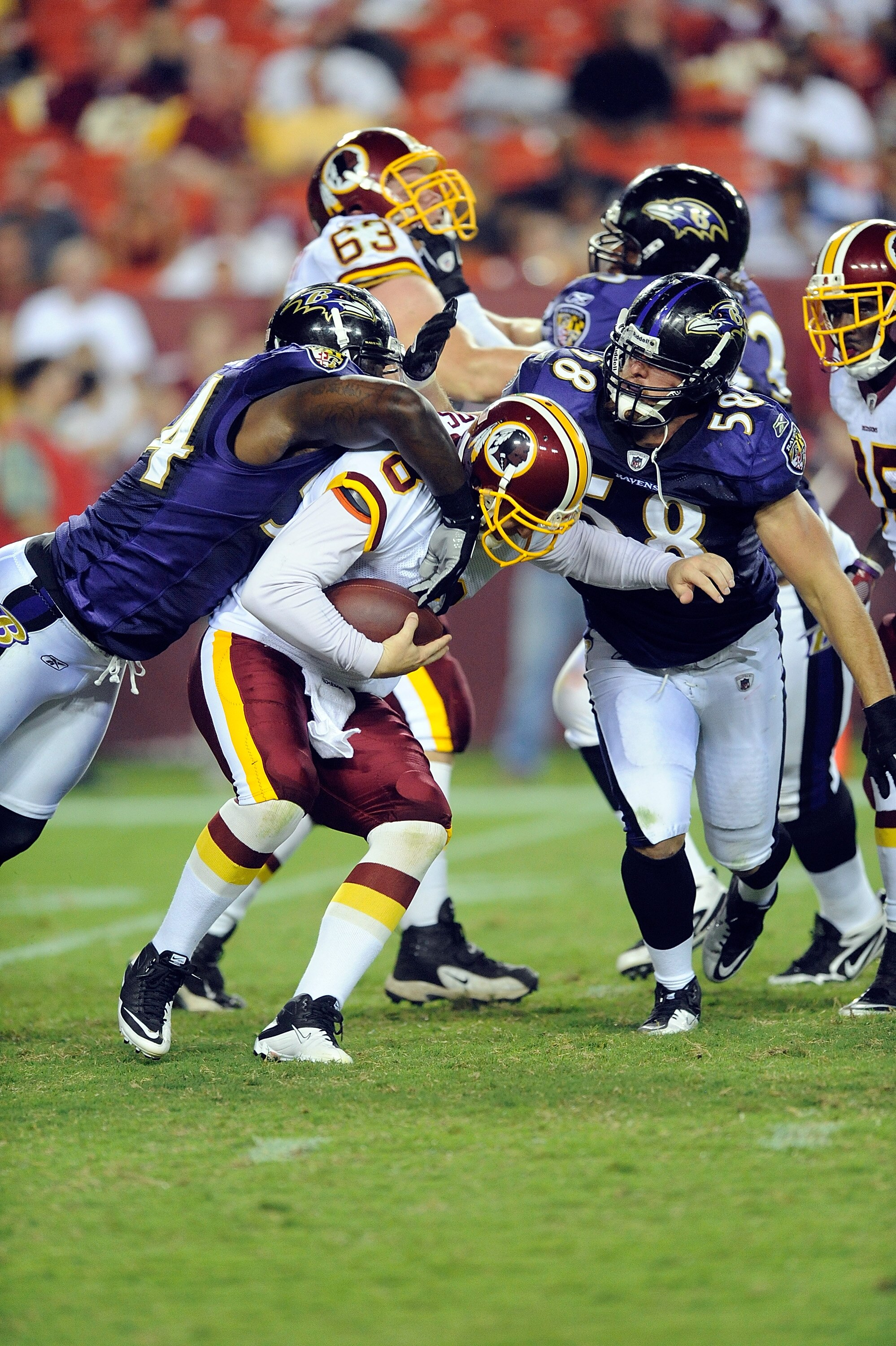 LANDOVER, MD - AUGUST 21:  Rex Grossman #8 of the Washington Redskins is sacked during the preseason game by Jason Phillips #58 and Prescott Burgess #54 of the Baltimore Ravens at FedExField on August 21, 2010 in Landover, Maryland.  (Photo by Greg Fiume/