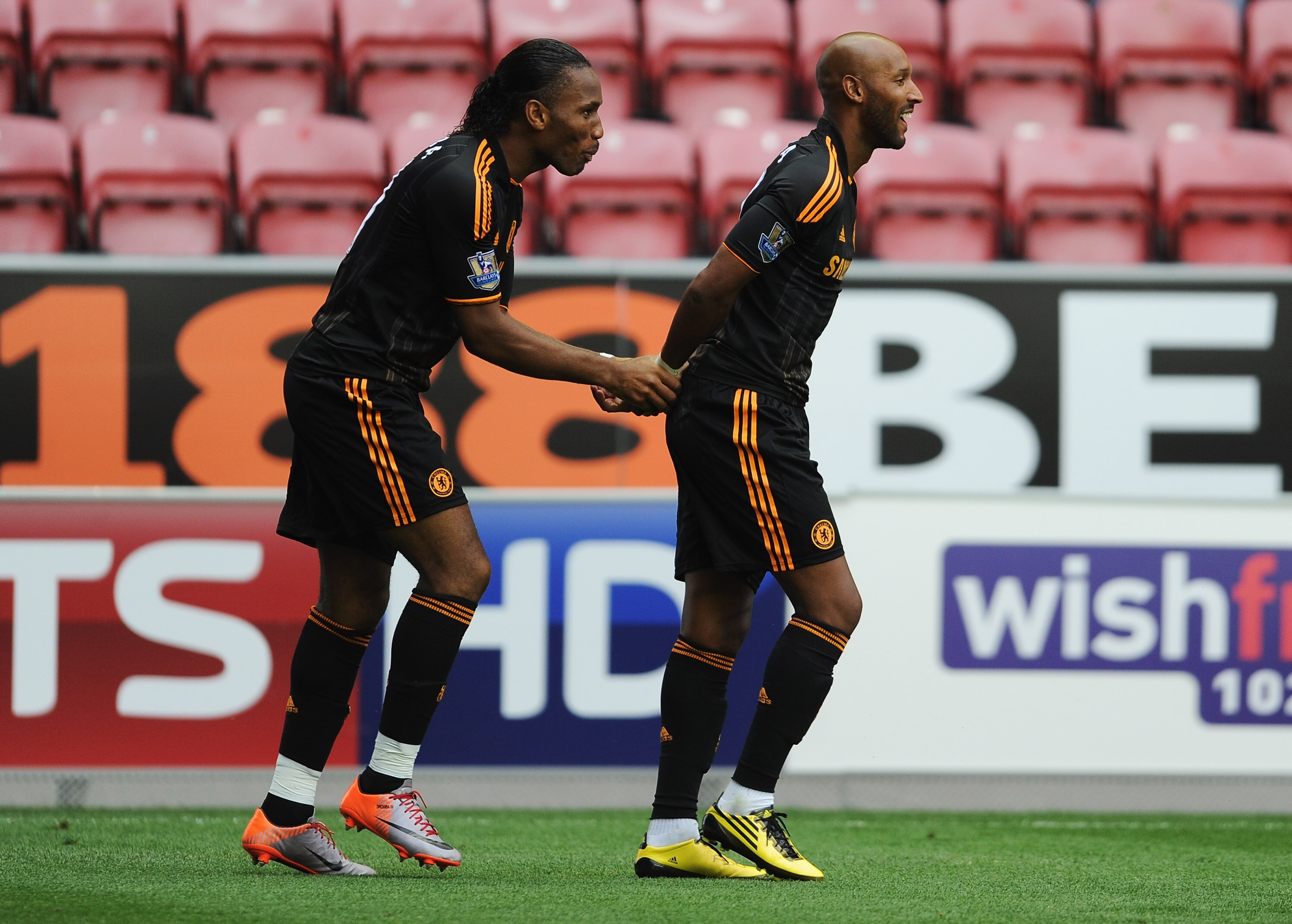 WIGAN, ENGLAND - AUGUST 21:  Nicolas Anelka of Chelsea celebrates with Didier Drogba as he scores their second goal during the Barclays Premier League match between Wigan Athletic and Chelsea at DW Stadium on August 21, 2010 in Wigan, England.  (Photo by