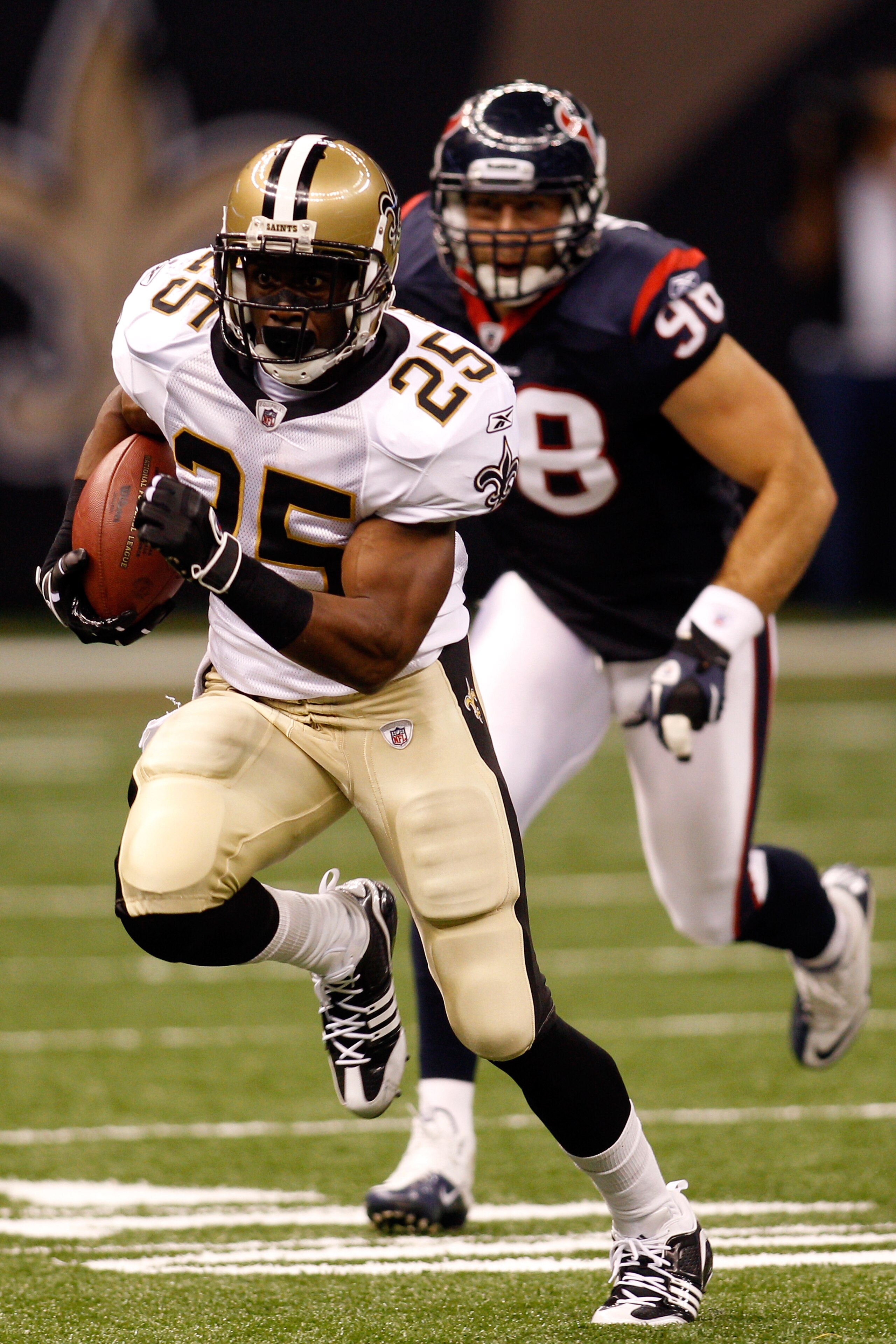 NEW ORLEANS - AUGUST 21:  Reggie Bush #25 of the New Orleans Saints runs pas Connor Barwin #98 of the Houston Texans at the Louisiana Superdome on August 21, 2010 in New Orleans, Louisiana.  The Saints defeated the Texans 38-20. (Photo by Chris Graythen/G