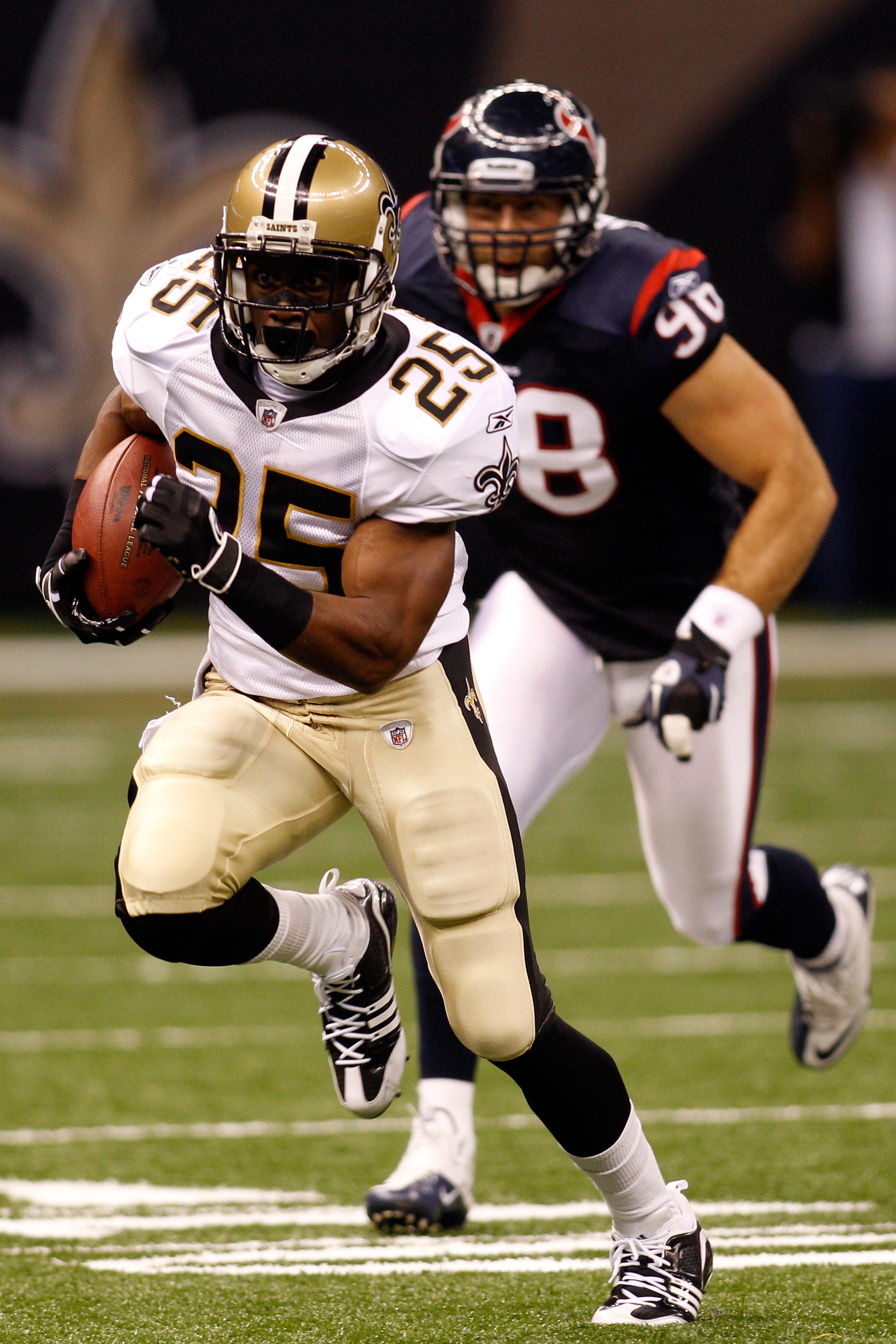 NEW ORLEANS - AUGUST 21:  Reggie Bush #25 of the New Orleans Saints runs pas Connor Barwin #98 of the Houston Texans at the Louisiana Superdome on August 21, 2010 in New Orleans, Louisiana.  The Saints defeated the Texans 38-20. (Photo by Chris Graythen/G