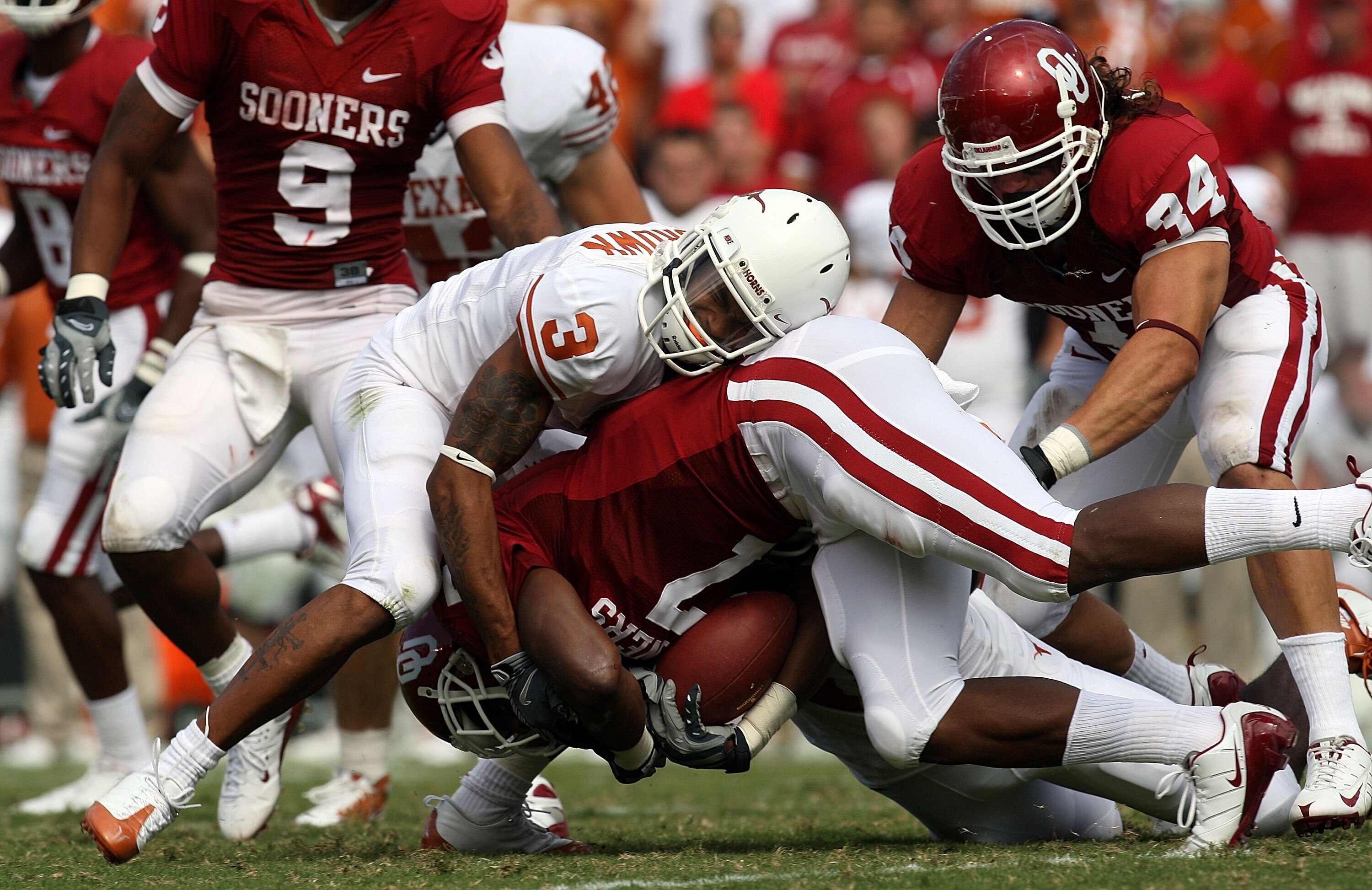 DALLAS - OCTOBER 11:  Running back DeMarco Murray #7 of the Oklahoma Sooners is tackled by Curtis Brown #3 of the Texas Longhorns during the Red River Rivalry at the Cotton Bowl on October 11, 2008 in Dallas, Texas.  (Photo by Ronald Martinez/Getty Images