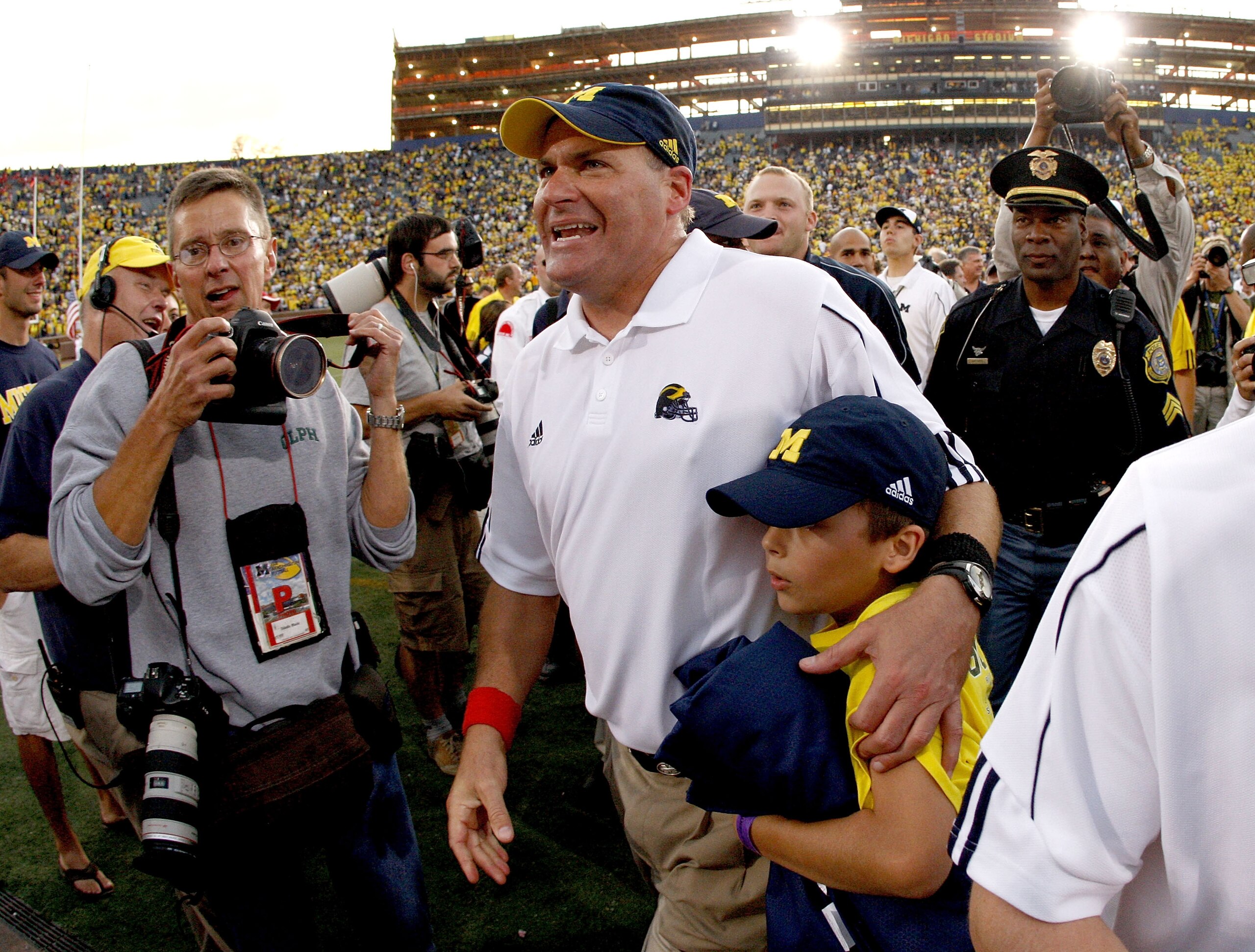 ANN ARBOR, MI - SEPTEMBER 27:  Head coach Rich Rodriguez of the Michigan Wolverines leaves the field with his son Rhett after defeating the Wisconsin Badgers on September 27, 2008 at Michigan Stadium in Ann Arbor, Michigan.  (Photo by Gregory Shamus/Getty