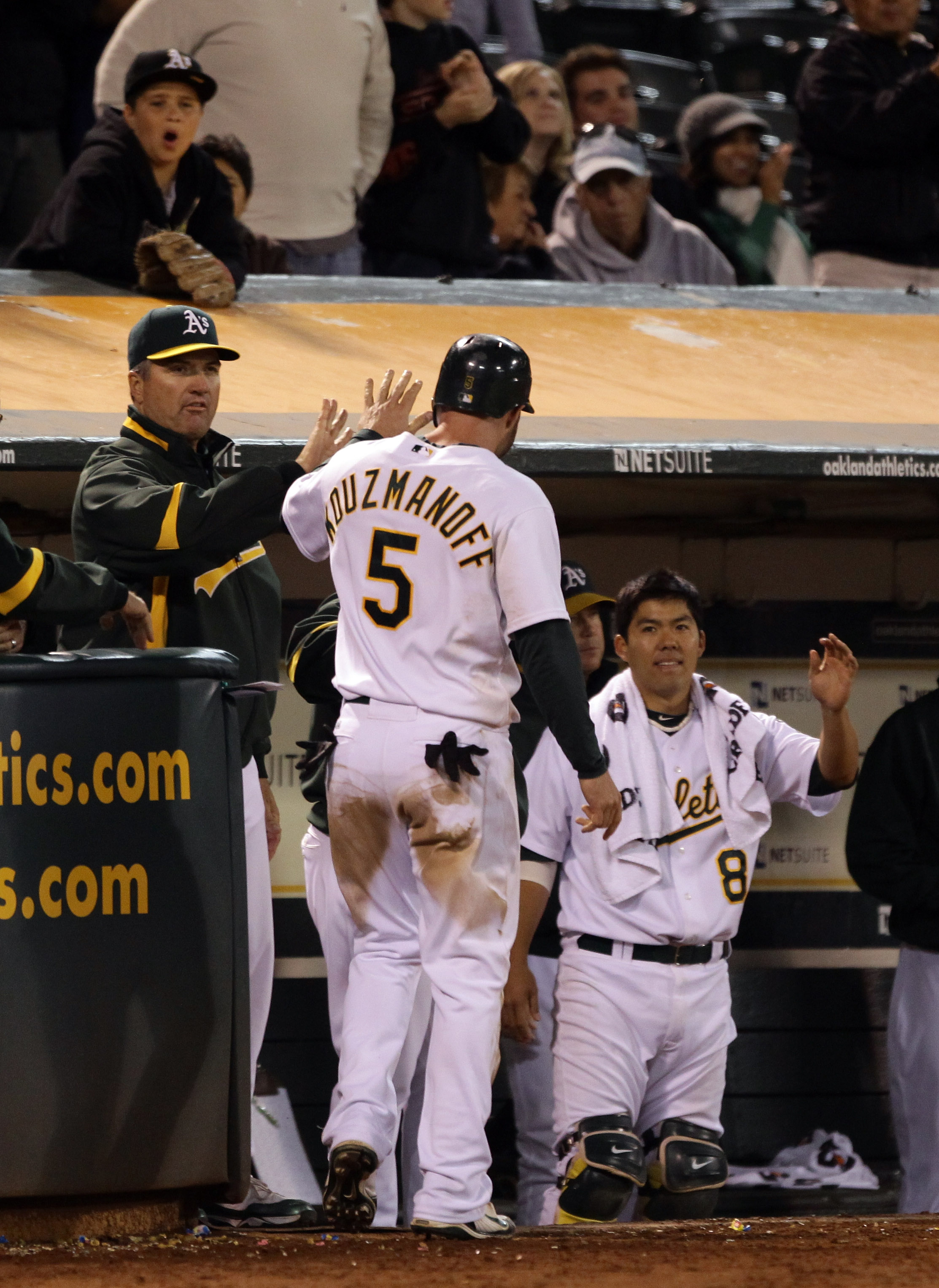 OAKLAND, CA - AUGUST 20:  Kevin Kouzmanoff #5 of the Oakland Athletics are congratulated by teammates after he scored on error by Ben Zobrist #18 of the Tampa Bay Rays to give the Athletics a 5-4 lead in the eighth inning at the Oakland-Alameda County Col