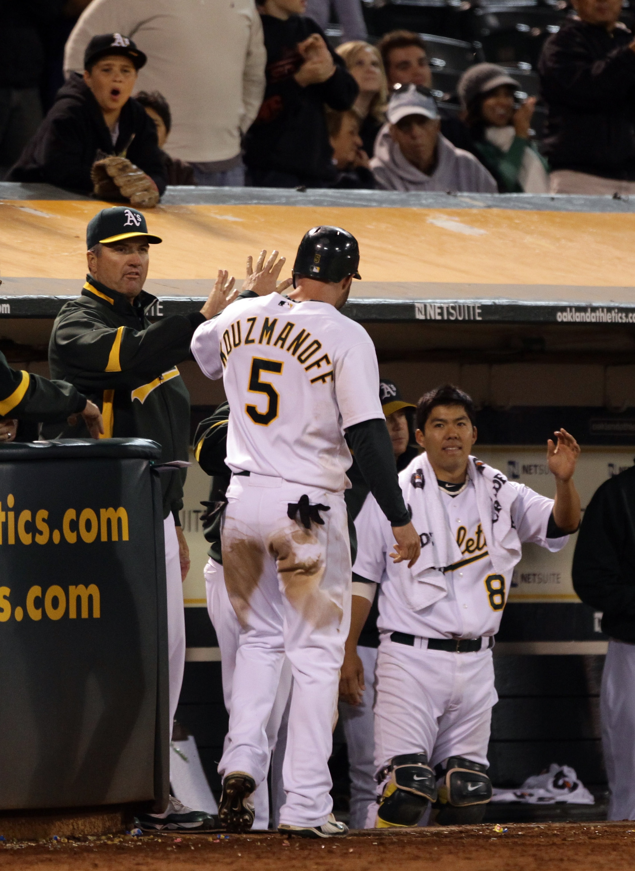 OAKLAND, CA - AUGUST 20:  Kevin Kouzmanoff #5 of the Oakland Athletics are congratulated by teammates after he scored on error by Ben Zobrist #18 of the Tampa Bay Rays to give the Athletics a 5-4 lead in the eighth inning at the Oakland-Alameda County Col