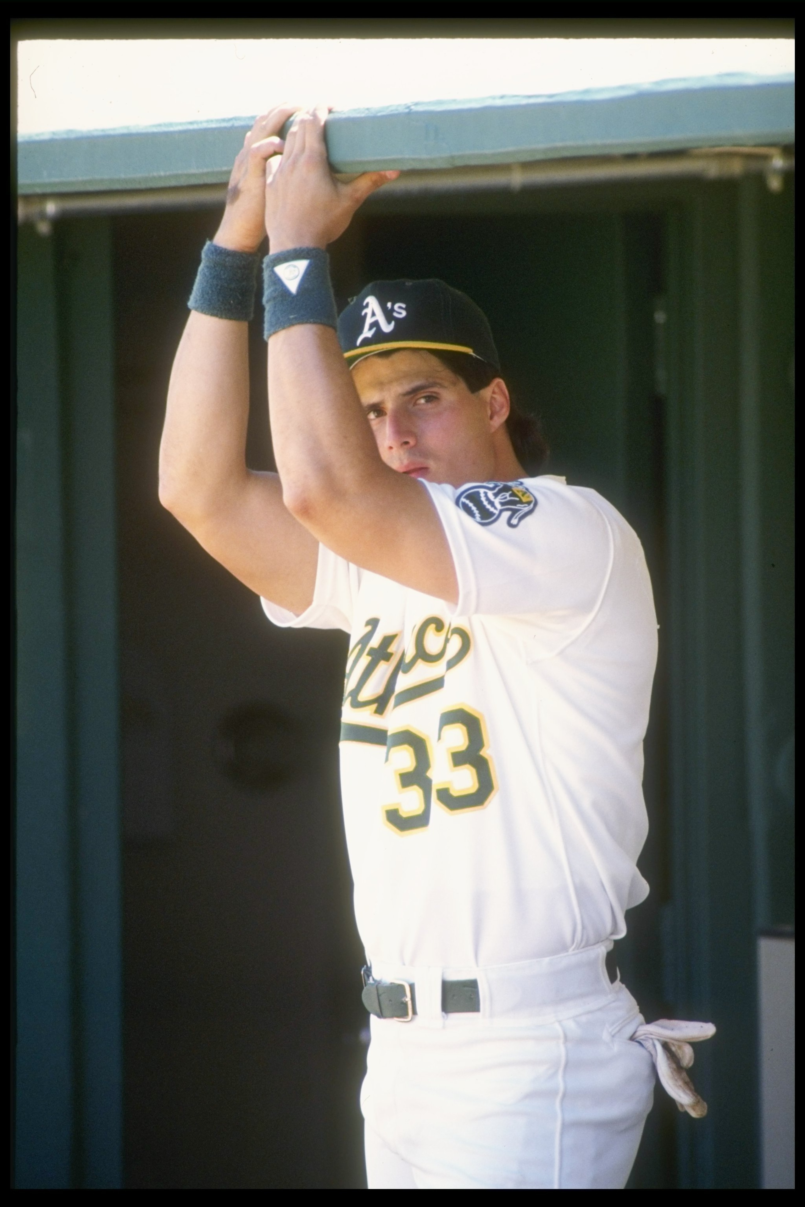 1990:  Outfielder Jose Canseco looks on from the dugout. Mandatory Credit: Otto Greule  /Allsport