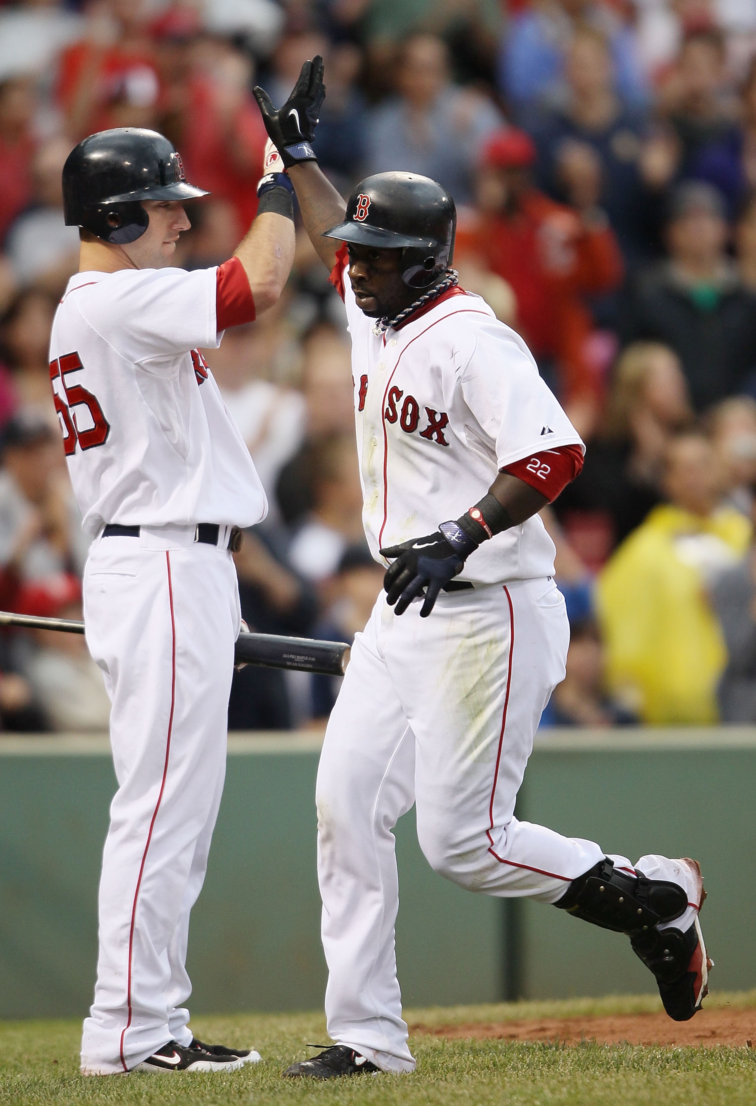 BOSTON - AUGUST 22:  Bill Hall #22 of the Boston Red Sox is congratulated by teammate Ryan Kalish #55 after Hall hit a two run homer in the fifth inning against the Toronto Blue Jays on August 22, 2010 at Fenway Park in Boston, Massachusetts.  (Photo by E