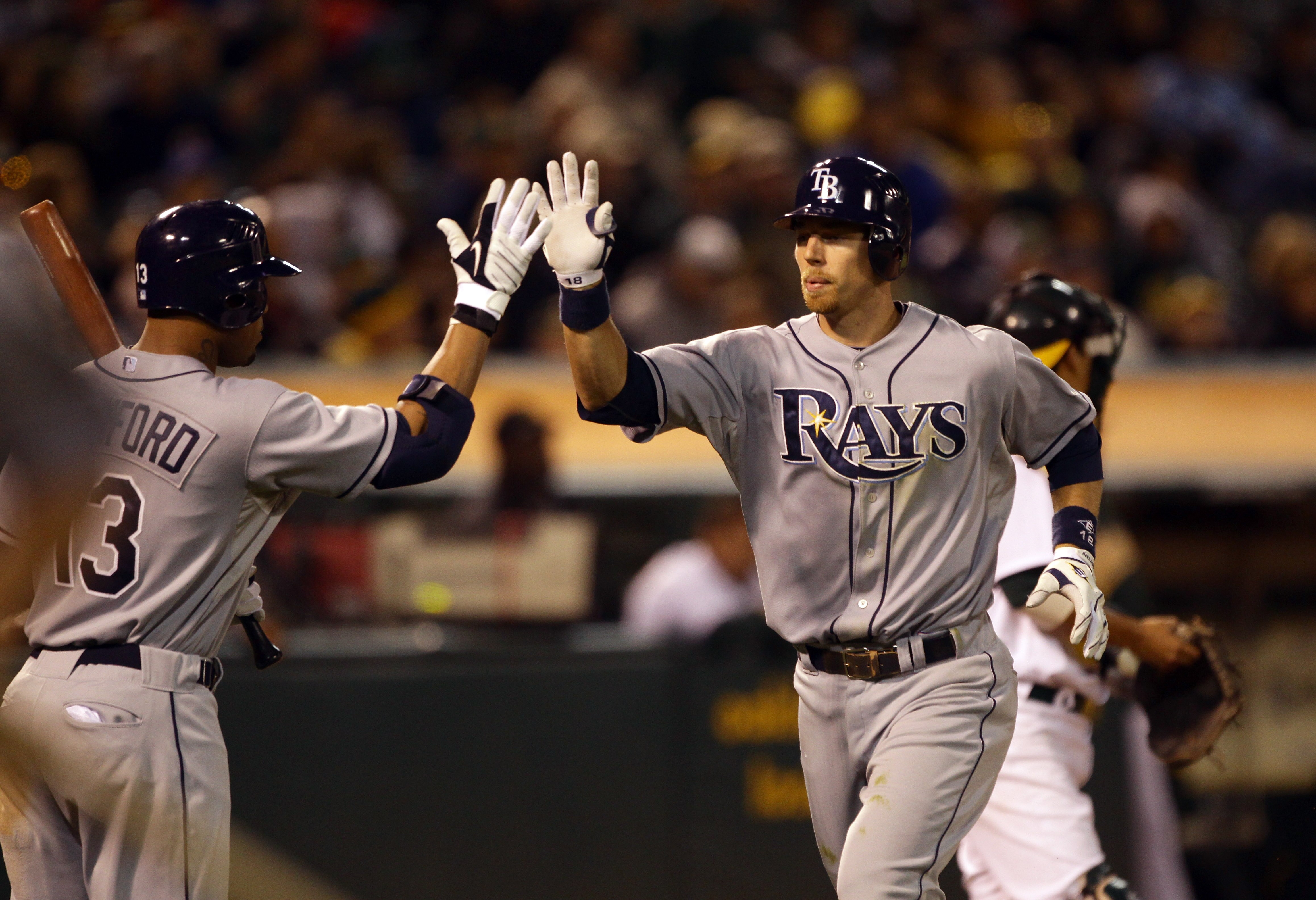 OAKLAND, CA - AUGUST 20:  Ben Zobrist #18 of the Tampa Bay Rays is congratulated by Carl Crawford #13 after he hit a home run to give the Rays a 4-3 lead in the seventh inning of their game against the Oakland Athletics at the Oakland-Alameda County Colis