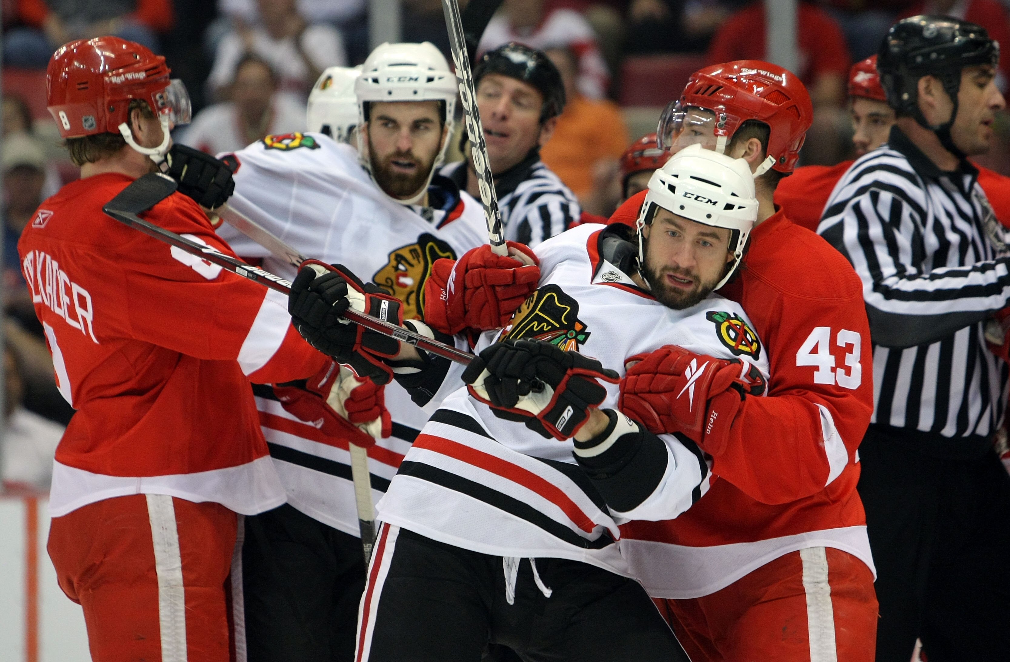 DETROIT - MAY 19:  Adam Burish #37 (2nd R) and Andrew Ladd #16 (2nd L) of the Chicago Blackhawks get tied up with Darren Helm #43 (R) and Justin Abdelkader #8 (L) of the Detroit Red Wings during Game Two of the Western Conference Championship Round of the