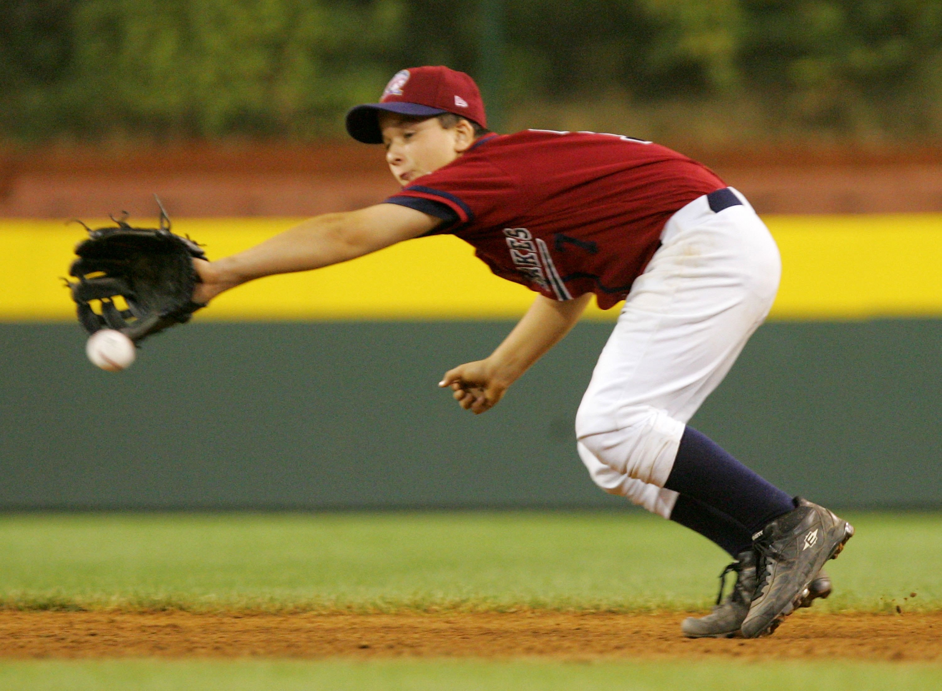 SOUTH WILLIAMSPORT, PA - AUGUST 23:  Michael Hall #7 of the Great Lakes team from Illinois can't come up with the ball on a double hit in the sixth inning by Sam Albert of the Northwest team from Oregon during the United States Semifinal game in the Littl