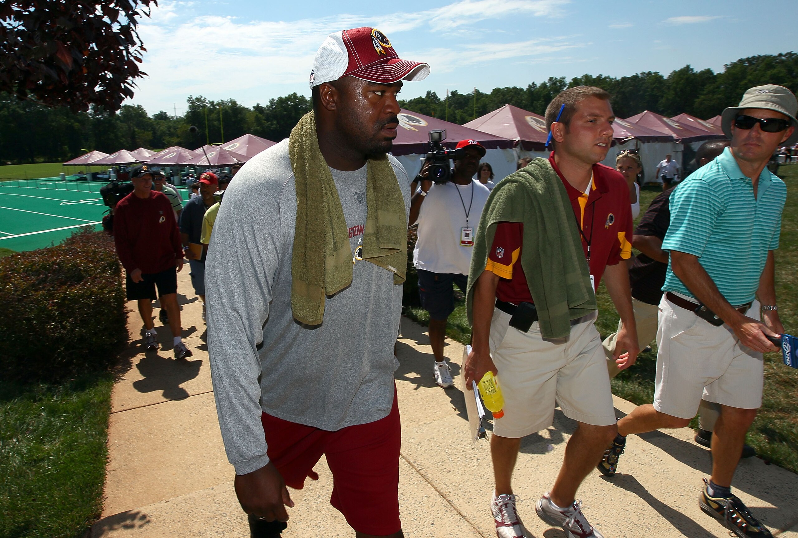ASHBURN, VA - JULY 30:  Defensive lineman Albert Haynesworth #92 (L) returns to the locker room following a workout session with Redskins defensive coordinator Jim Haslett (2nd L) on the second day of training camp July 30, 2010 in Ashburn, Virginia. Hayn