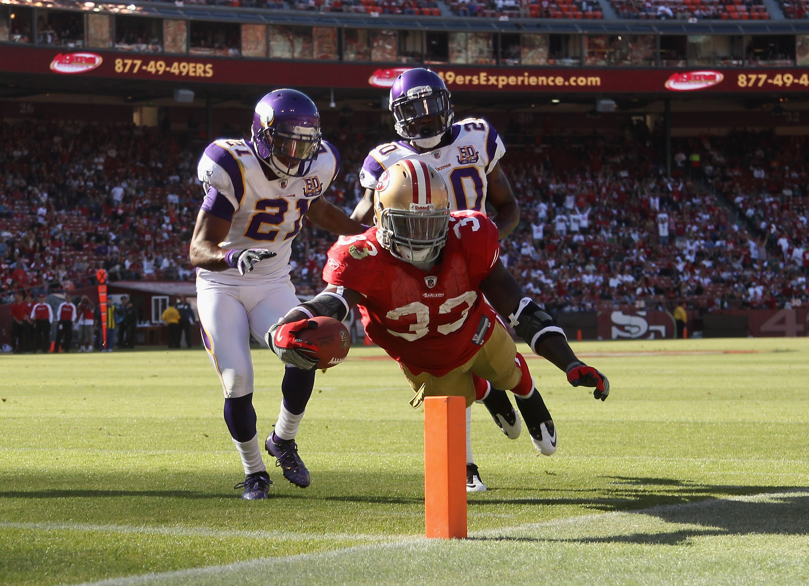SAN FRANCISCO - AUGUST 22:  Anthony Dixon #33 of the San Francisco 49ers dives past Madieu Williams #20 and Asher Allen #21 of the Minnesota Vikings at Candlestick Park on August 22, 2010 in San Francisco, California.  (Photo by Ezra Shaw/Getty Images)