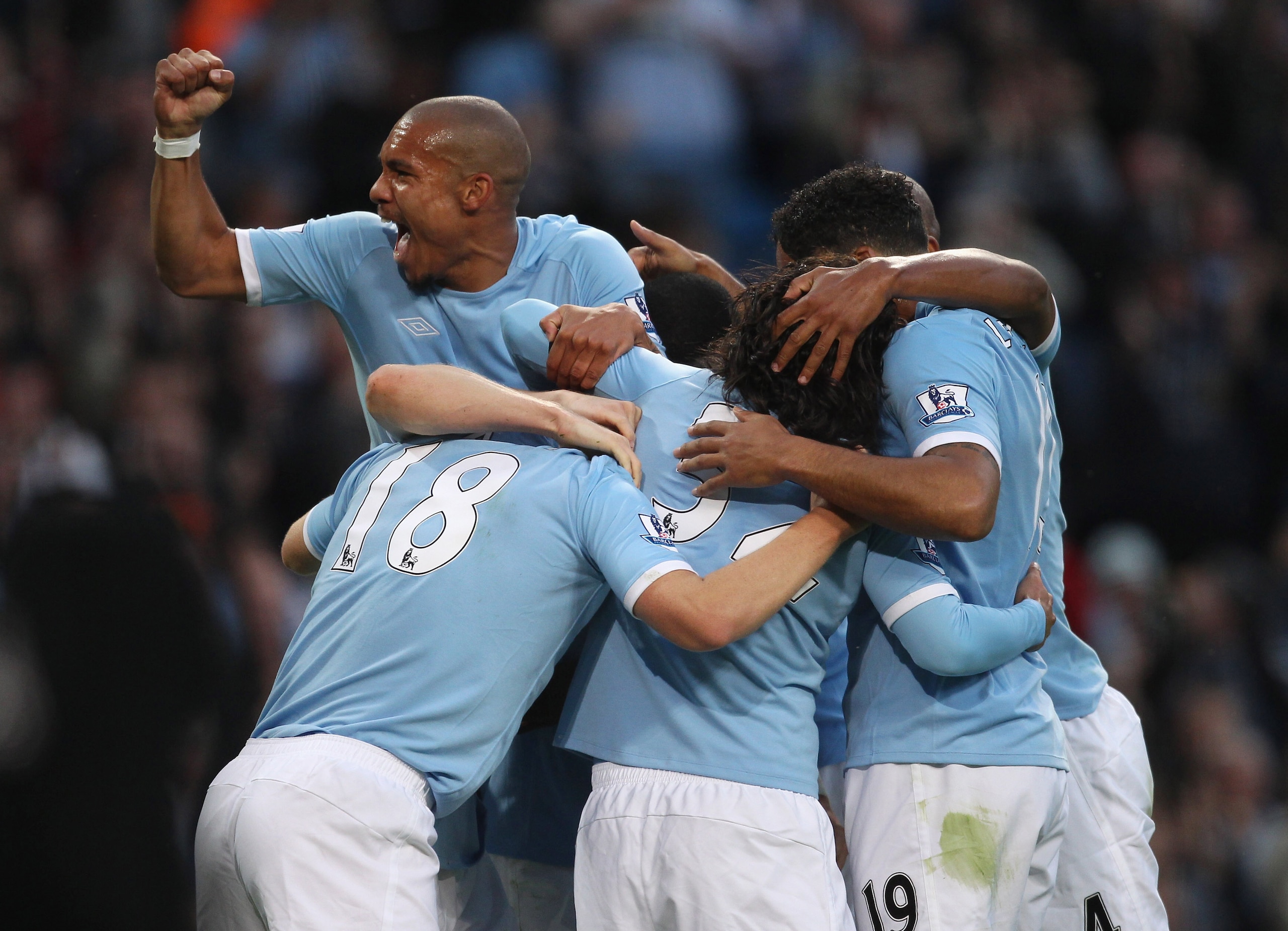 MANCHESTER, ENGLAND - AUGUST 23:   Nigel de Jong of Manchester City punches the air as Gareth Barry of Manchester City is mobbed by team mates after scoring the opening goal during the Barclays Premier League match between Manchester City and Liverpool at