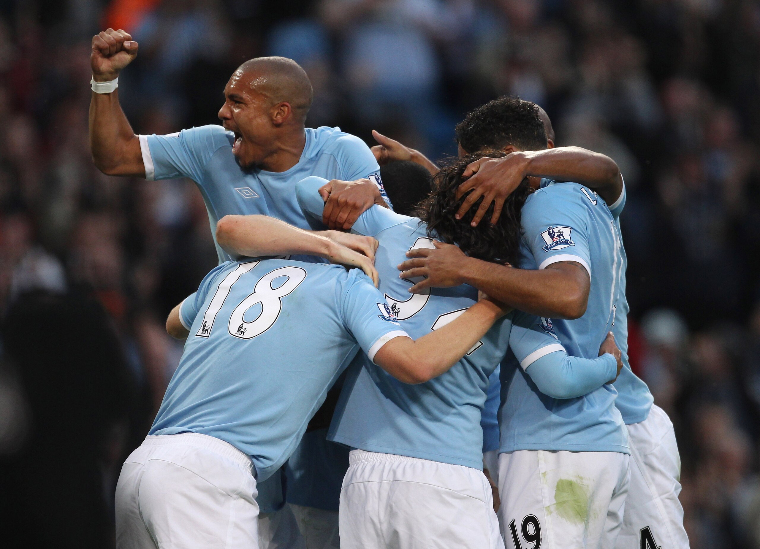 MANCHESTER, ENGLAND - AUGUST 23:   Nigel de Jong of Manchester City punches the air as Gareth Barry of Manchester City is mobbed by team mates after scoring the opening goal during the Barclays Premier League match between Manchester City and Liverpool at