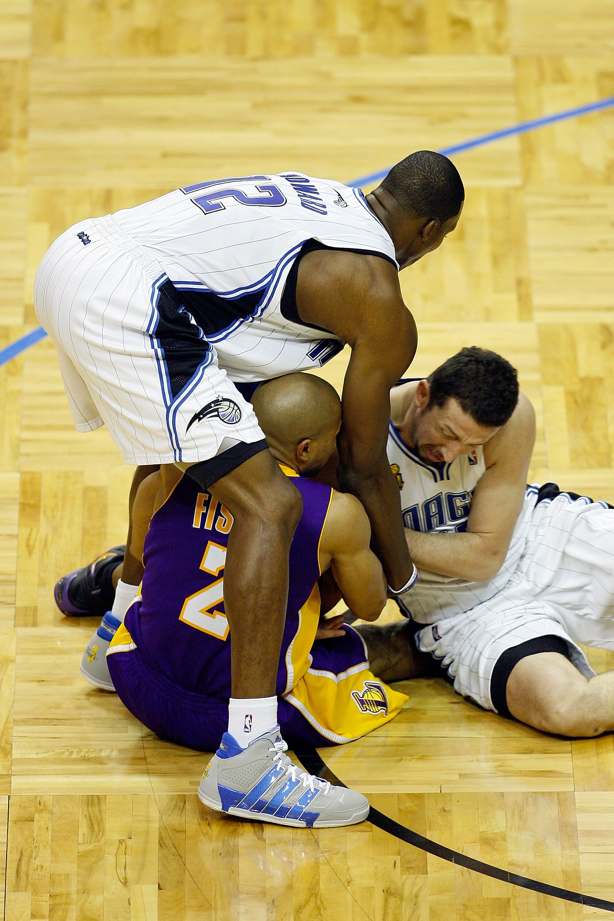 ORLANDO, FL - JUNE 14:  Derek Fisher #2 of the Los Angeles Lakers holds the ball as both Dwight Howard #12 and Hedo Turkoglu #15 of the Orlando Magic go after it in Game Five of the 2009 NBA Finals on June 14, 2009 at Amway Arena in Orlando, Florida.  NOT