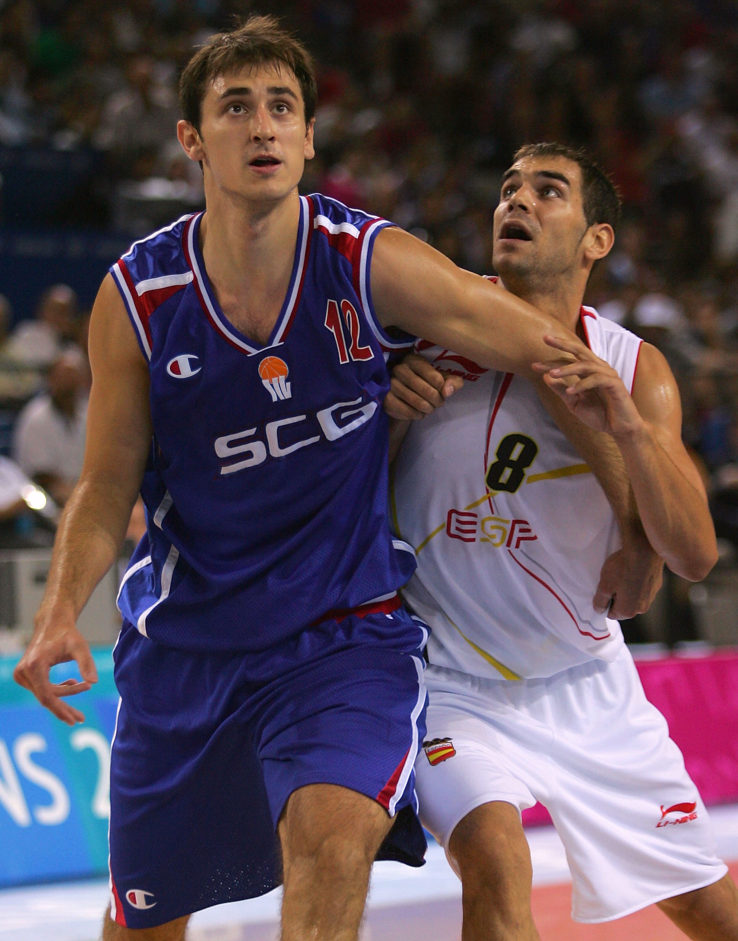 ATHENS - AUGUST 21:  Nenad Krstic #12 (L) for Serbia and Montenegro fights for position against Jose Calderon #8 of Spain in a men's basketball preliminary game August 21, 2004 during the Athens 2004 Summer Olympic Games at the Indoor Arena of the Hellini