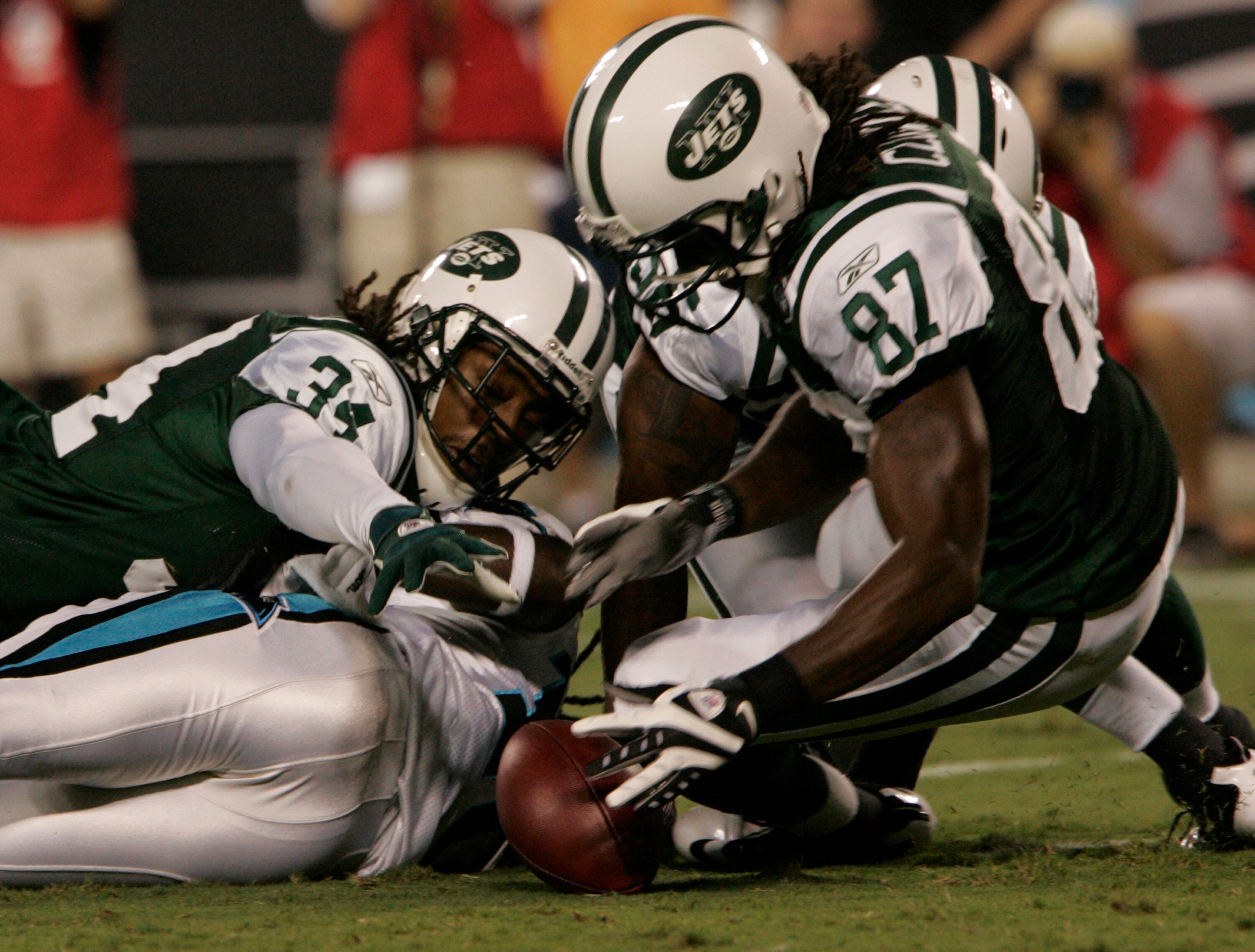 CHARLOTTE,NC- AUGUST 21:  Armanti Edwards #10 of the Carolina Panthers fumbles the ball as David Clowney #87 and Marquice Cole #34 of the New York Jets recover the ball during a preseason game at Bank of America Stadium on August 21, 2010 in Charlotte, No