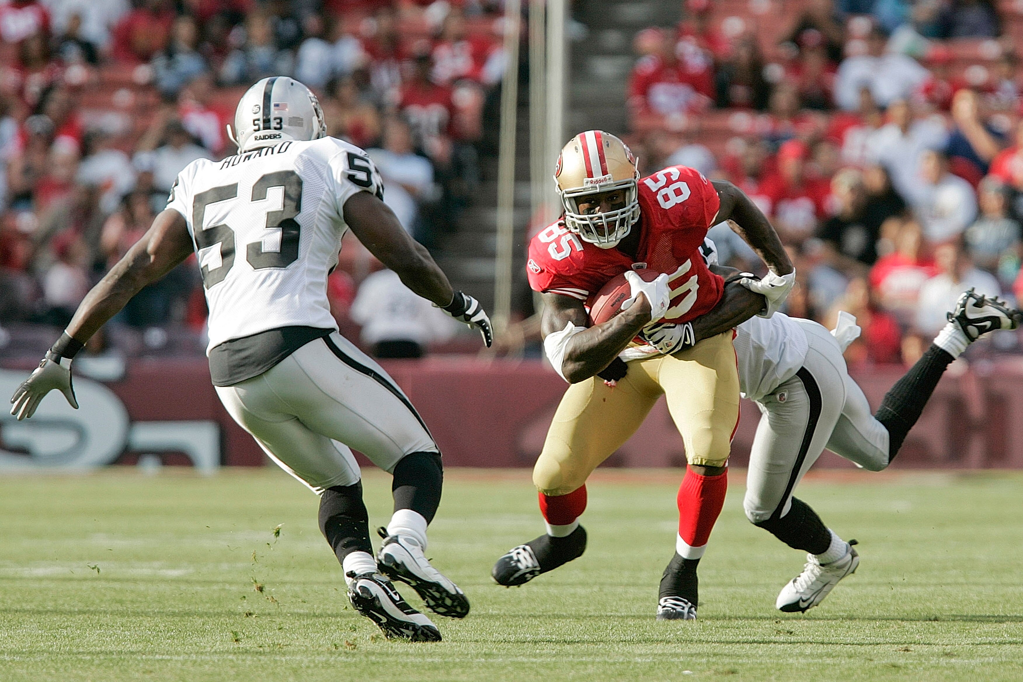 SAN FRANCISCO - AUGUST 22:  San Francisco 49ers tight end Vernon Davis #85 runs as Oakland Raiders linebacker Thomas Howard #53 defends during the 1st quarter as the San Francisco 49ers host the Oakland Raiders at Candlestick Park August 22, 2009 in San F
