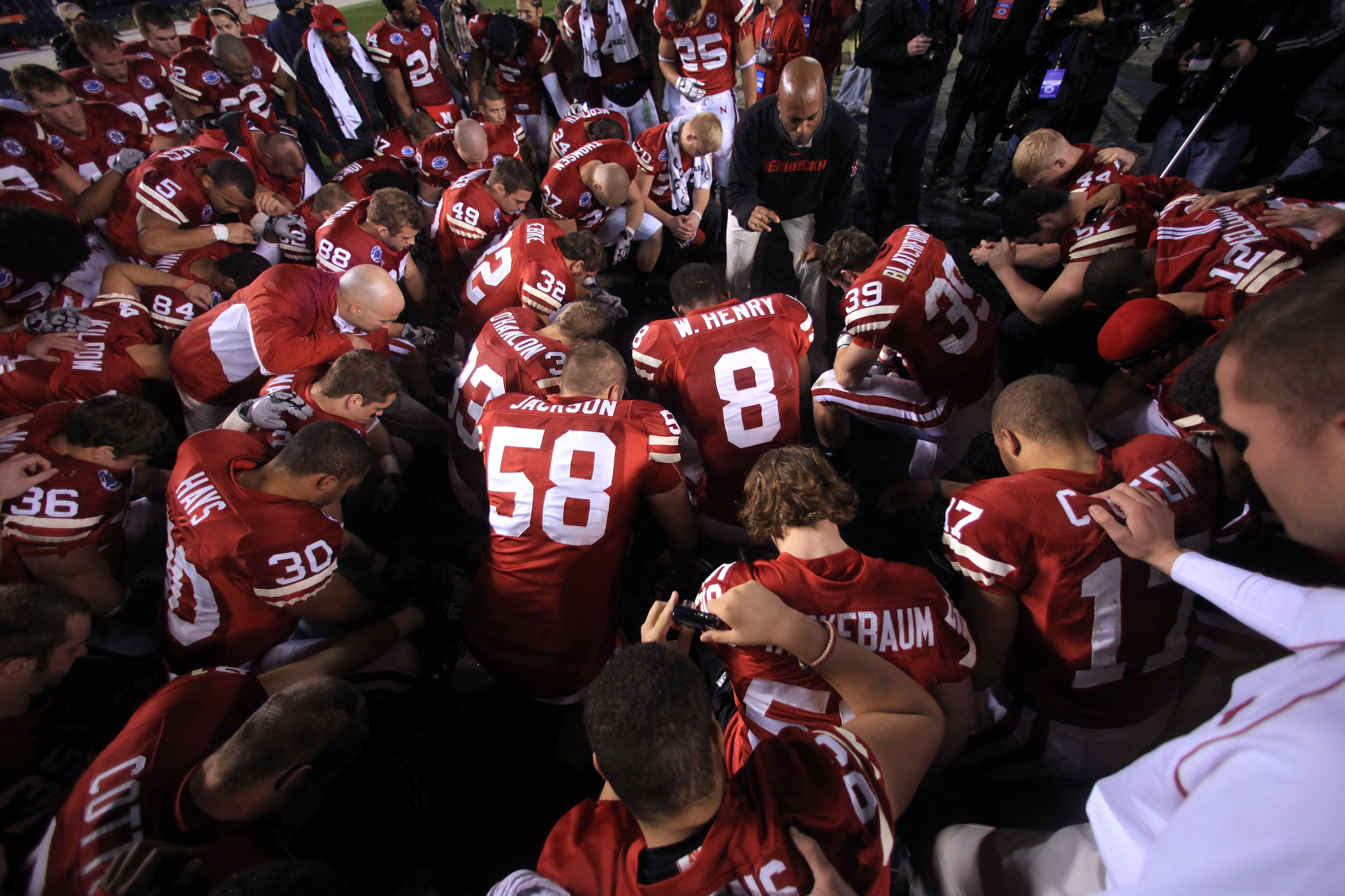 SAN DIEGO - DECEMBER 30:  Members of the University of Nebraska Cornhuskers pray on field after their 33-0 victory against the against the University of Arizona Wildcats during the Pacific Life Holiday Bowl, on December 30, 2009 at Qualcomm Stadium in San