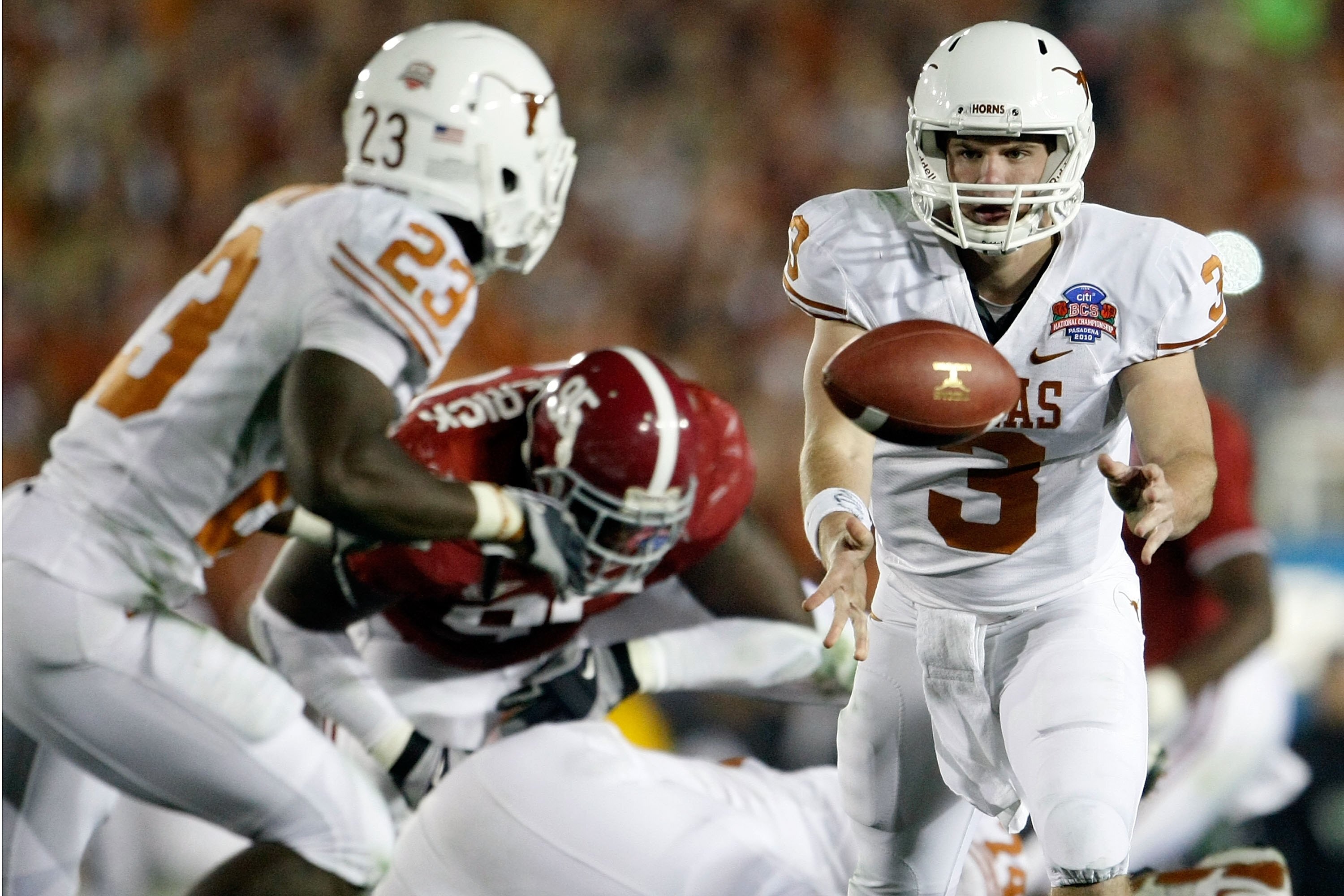PASADENA, CA - JANUARY 07:  Quarterback Garrett Gilbert #3 of the Texas Longhorns pitches the ball back to Tre' Newton #23 against the Alabama Crimson Tide during the Citi BCS National Championship game at the Rose Bowl on January 7, 2010 in Pasadena, Cal