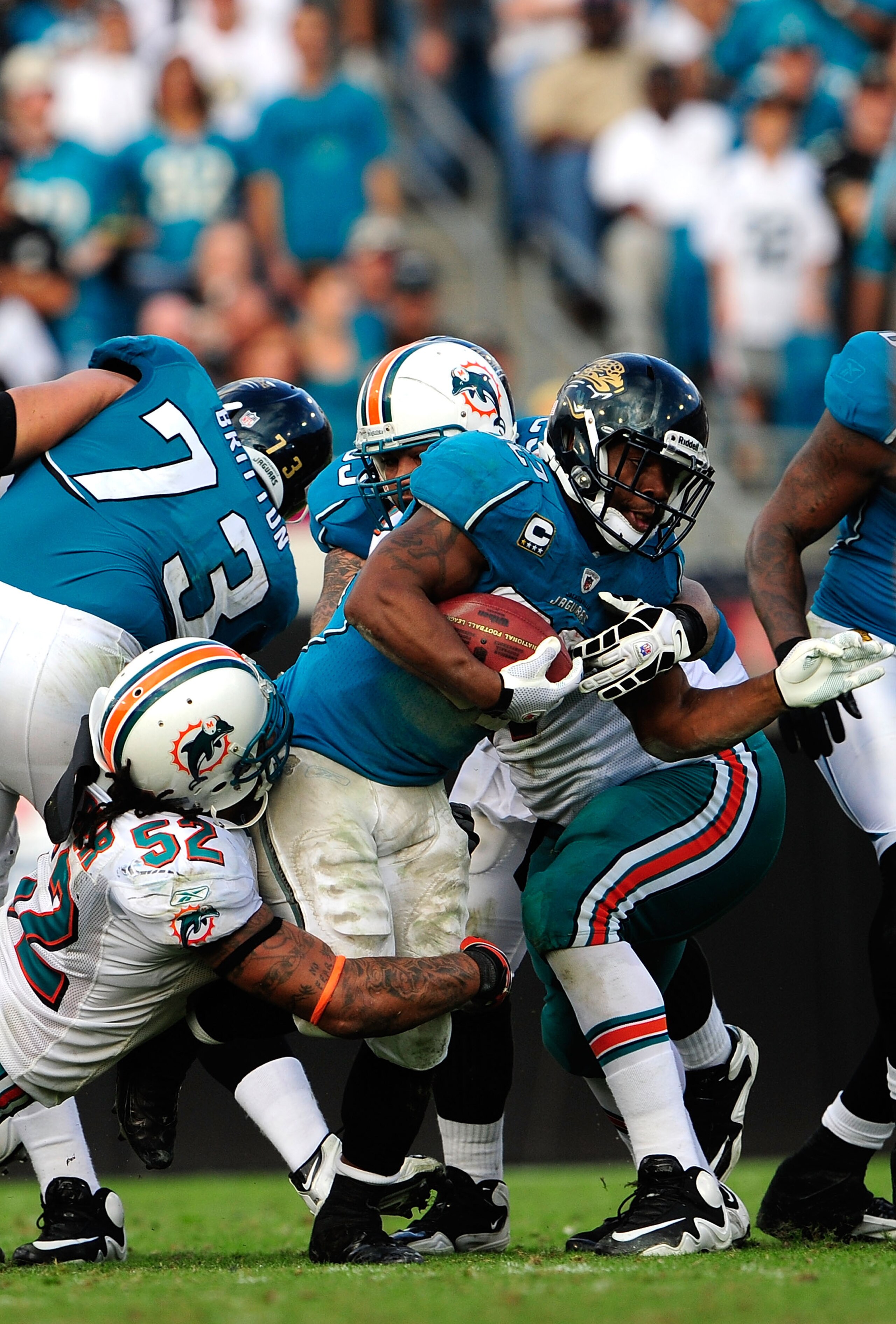 JACKSONVILLE, FL - DECEMBER 13:  Maurice Jones-Drew #32 of the Jacksonville Jaguars is tackled by Channing Crowder #52 of the Miami Dolphins during the game at Jacksonville Municipal Stadium on December 13, 2009 in Jacksonville, Florida.  The Dolphins won