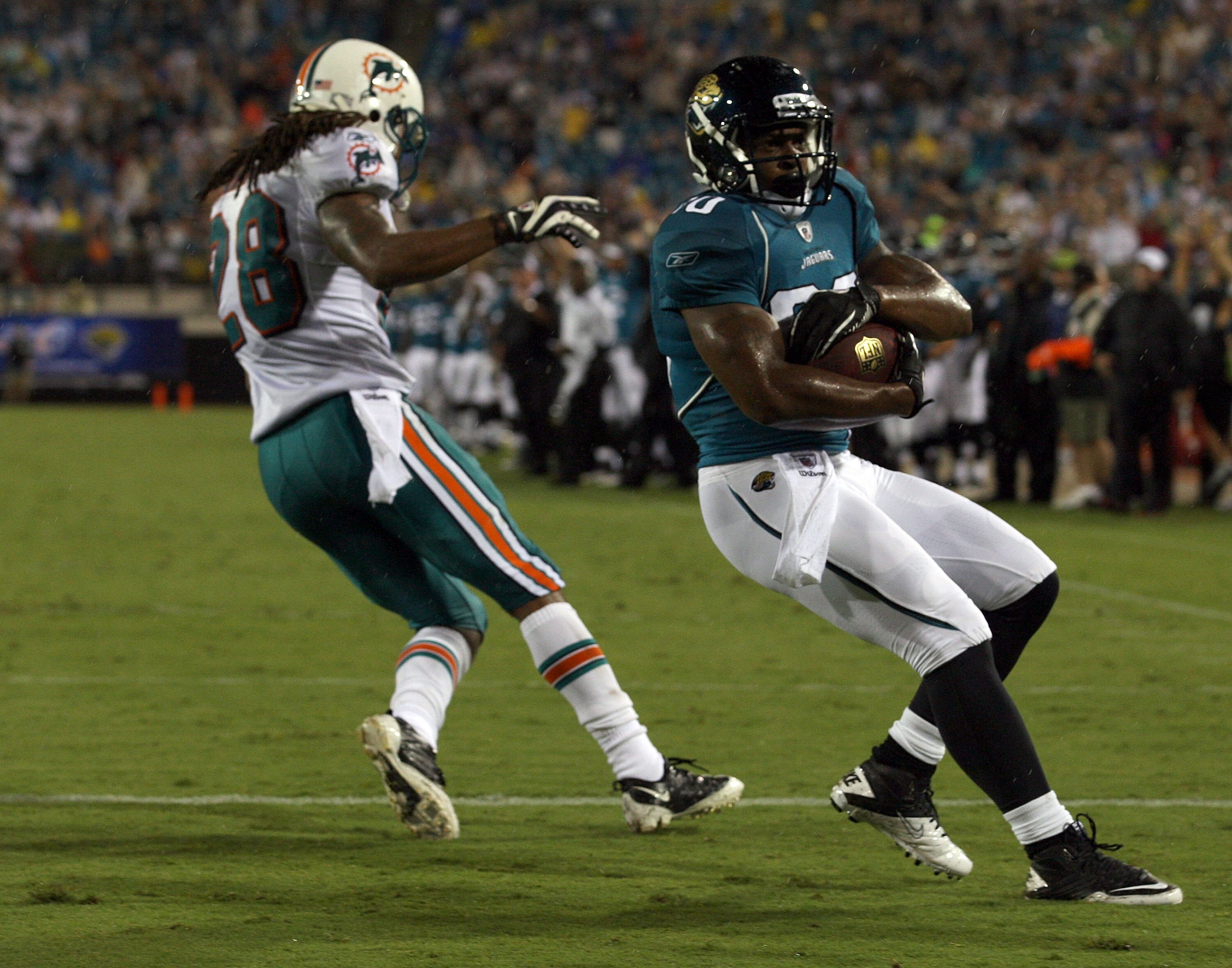 JACKSONVILLE, FL - AUGUST 21:  Mike Thomas #80 of the Jacksonville Jaguars scores a touchdown against Nolan Carroll #28 of the Miami Dolphins during the preseason game at EverBank Field on August 21, 2010 in Jacksonville, Florida.  (Photo by Sam Greenwood