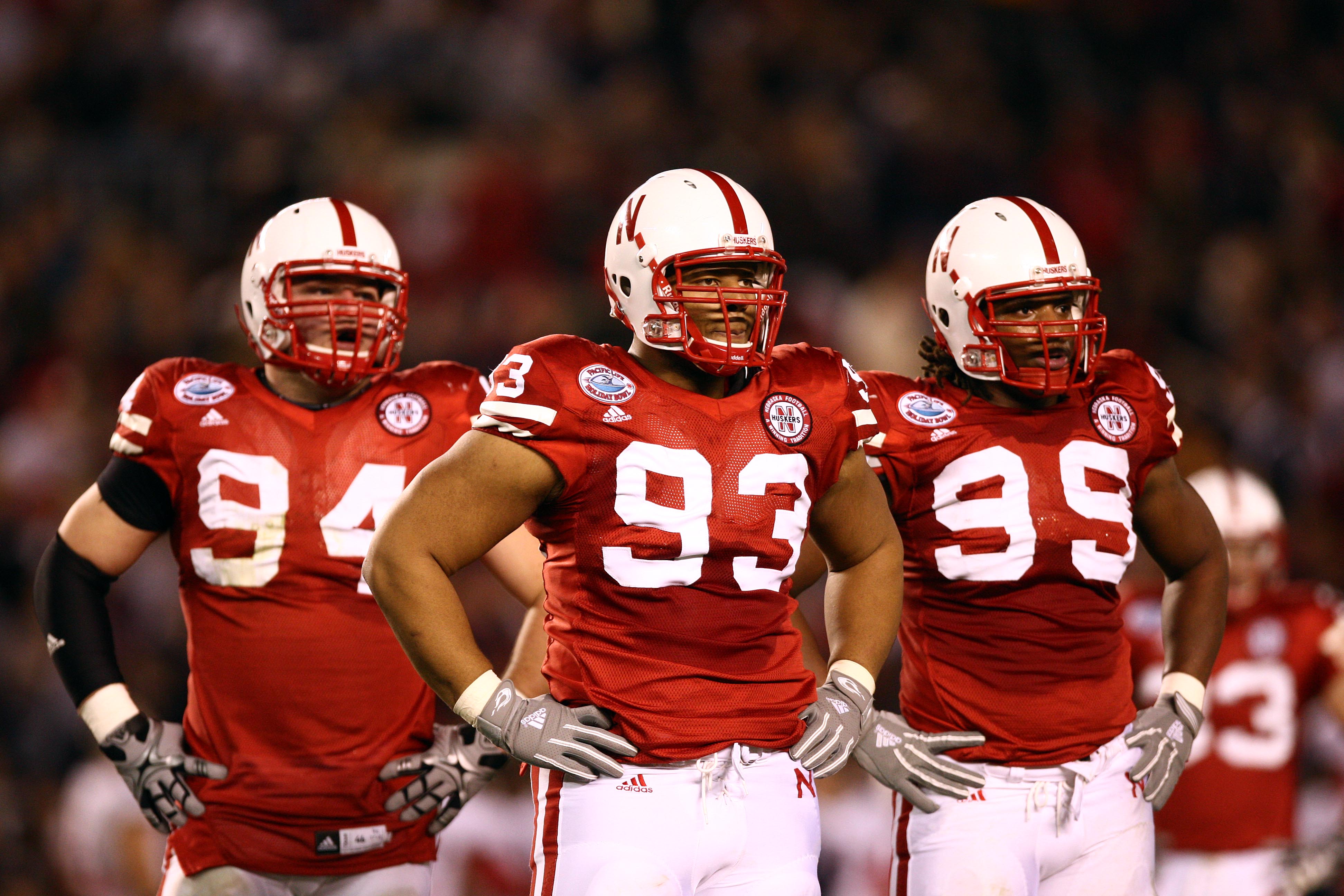 SAN DIEGO, CA - DECEMBER 30:  Defensive Tackle Ndamukong Suh #93 of the University of Nebraska Cornhuskers looks on with teammates Jared Crick #94 and Barry Turner #99 against the University of Arizona Wildcats during the Pacific Life Holiday Bowl,  on De