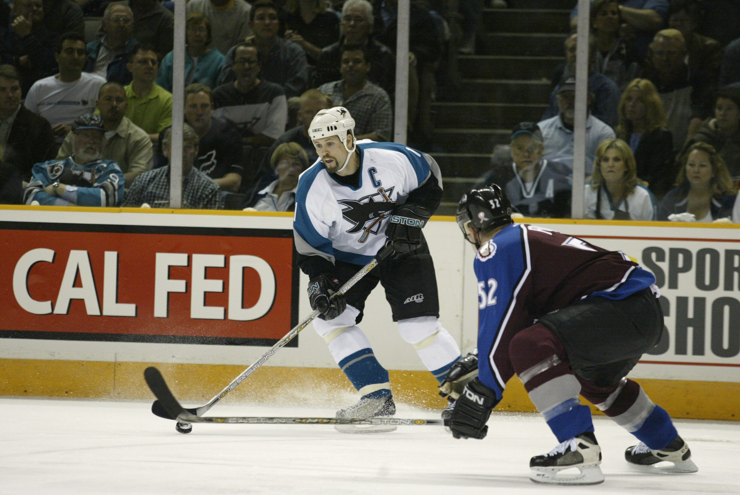 SAN JOSE, CA - MAY 13:   Right Wing Owen Nolan #11 of the San Jose Sharks  looks to play the puck against defenseman Adam Foote#52 of the Colorado Avalanche during Game 6 of the Western Conference Semifinals of the NHL Stanley Cup Playoffs at the Compaq C