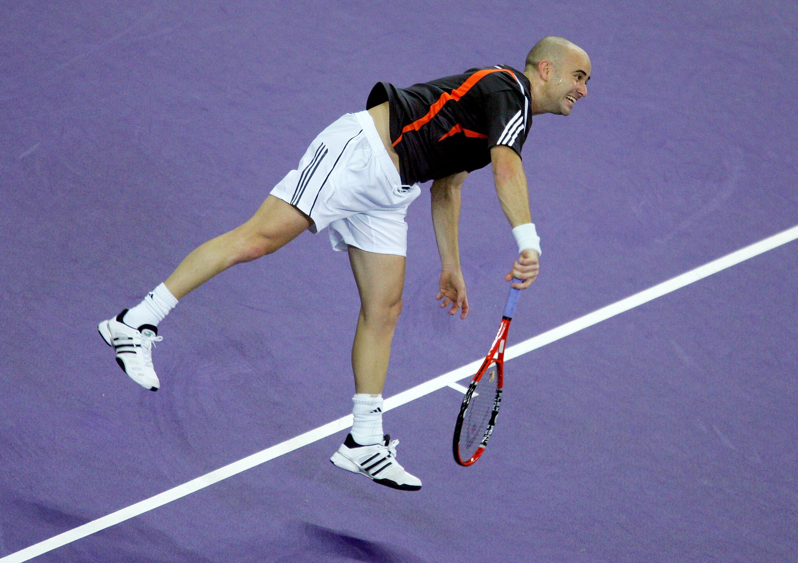 SHANGHAI, CHINA - NOVEMBER 14: Andre Agassi of the United States serve to Nikolay Davydenko of Russia during the Tennis Masters Cup at Qi Zhong Stadium November 14, 2005 in Shanghai, China. (Photo by Matthew Stockman/Getty Images)