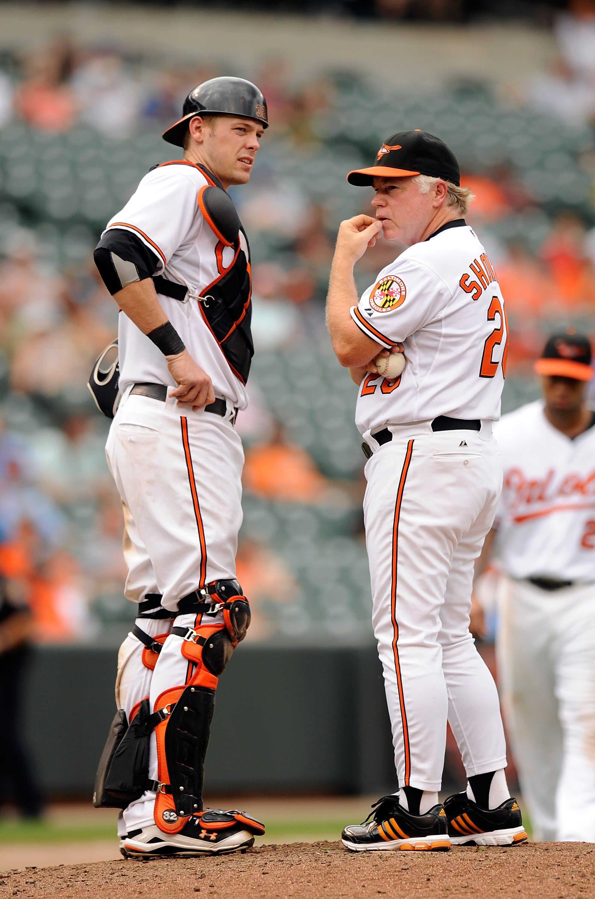 BALTIMORE - AUGUST 22:  Matt Wieters #32 of the Baltimore Orioles talks with manager Buck Showalter during a pitching change in the game against the Texas Rangers at Camden Yards on August 22, 2010 in Baltimore, Maryland. The Rangers beat the Orioles 6-4.