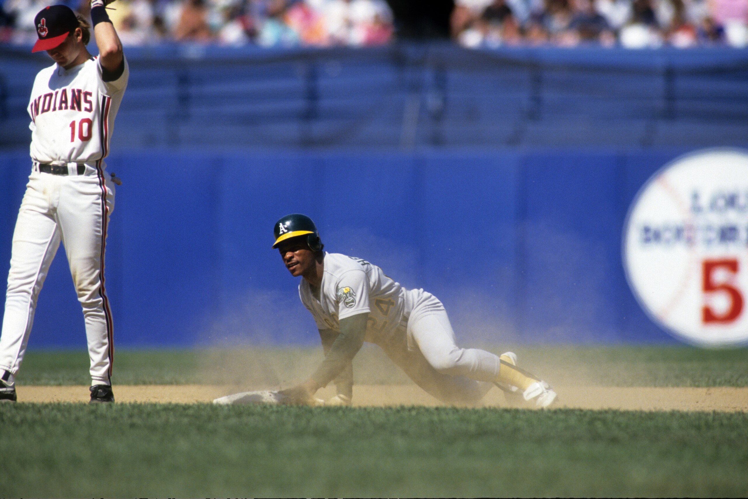 CLEVELAND - MAY 1991:  Rickey Henderson #24 of the Oakland Athletics slides to second base during their MLB game against the Cleveland Indians circa May 1991 at Cleveland Municipal Stadium in Cleveland, Ohio. (Photo by Rick Stewart/Getty Images)